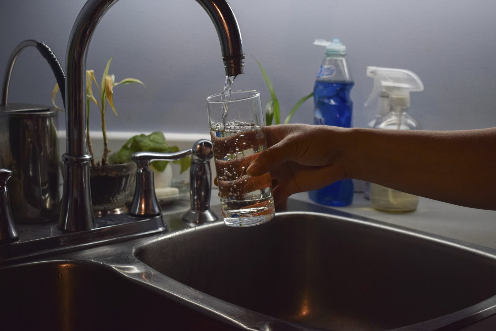 In this July 21, 2019 photo, Florabela Cunha fills a glass of water from her kitchen faucet in Prince Rupert, British Columbia, Canada. In previous summers she used to make iced tea for her family using water from her tap, but has since stopped citing concerns about the water quality. Hundreds of thousands of Canadians from coast to coast have been unwittingly exposed to levels of lead in their drinking water.