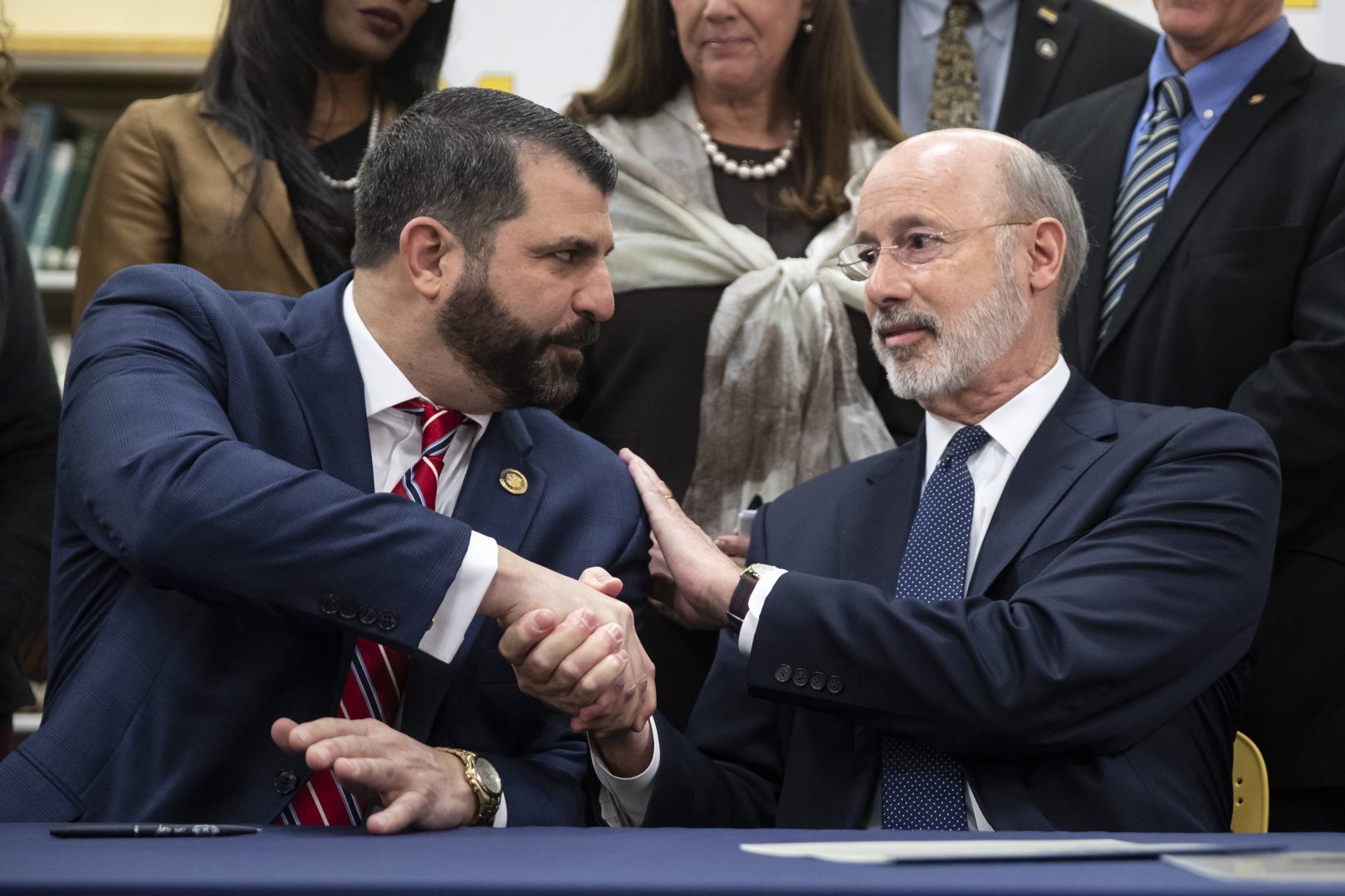 FILE PHOTO: Pennsylvania Gov. Tom Wolf, right, shakes hands with Rep. Mark Rozzi, D-Berks, after signing legislation into law at Muhlenberg High School in Reading, Pa., Tuesday, Nov. 26, 2019. Wolf approved legislation Tuesday to give future victims of child sexual abuse more time to file lawsuits and to end time limits for police to file criminal charges.