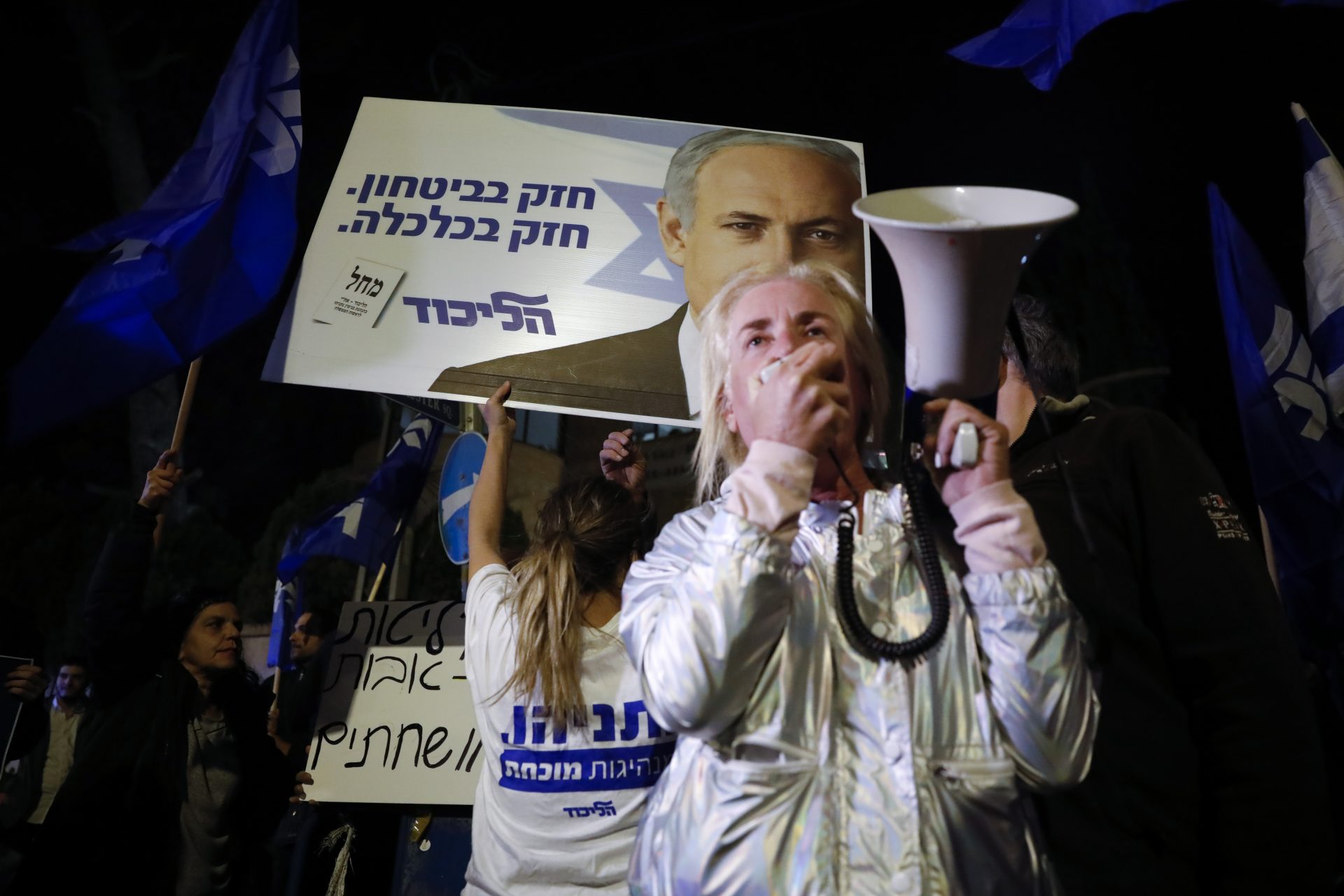 Supporters of Israeli Prime Minister Benjamin Netanyahu gather outside his residence in Jerusalem, Thursday, Nov. 21, 2019. Israel's attorney general charged Netanyahu with fraud, breach of trust and accepting bribes in three different scandals. It is the first time a sitting Israeli prime minister has been charged with a crime.