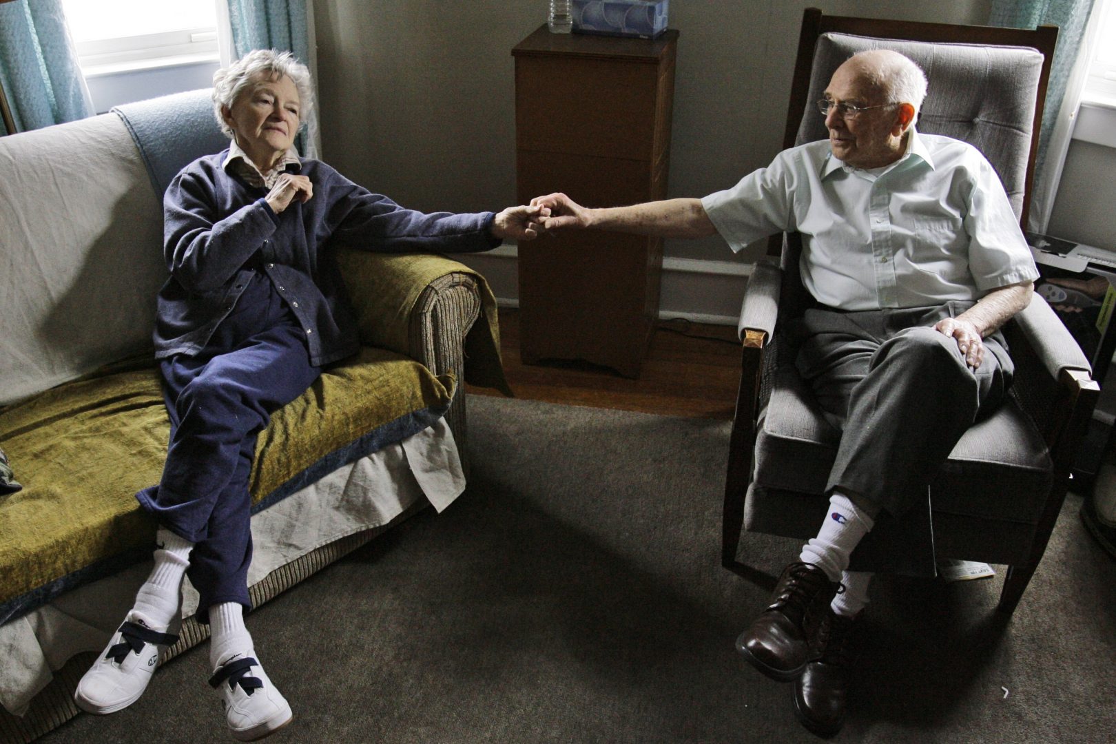 Alzheimer's patient Dorothy Eckert and her husband John Eckert's hold hands at their home  in Norristown Pa., Thursday, April 19, 2007. Alzheimer's caregivers seldom can make time in their daily grind to seek out help. And when they do, they too often find waiting lists for services, or programs geared only toward people with advanced disease and not the larger pool in the purgatory that is dementia's decade-long middle ground between independence and helplessness. 