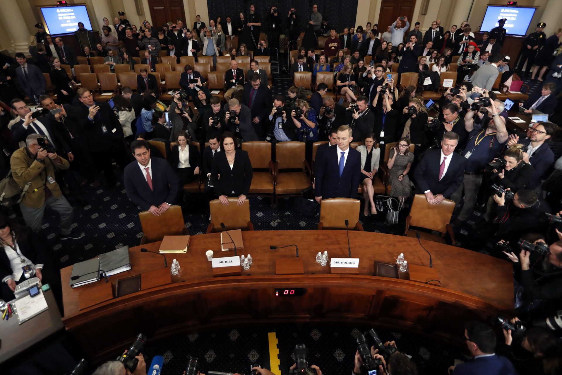 Former White House national security aide Fiona Hill, second from left, and David Holmes, a U.S. diplomat in Ukraine, stand behind their chairs as they arrive to testify before the House Intelligence Committee on Capitol Hill in Washington, Thursday, Nov. 21, 2019, during a public impeachment hearing of President Donald Trump's efforts to tie U.S. aid for Ukraine to investigations of his political opponents.