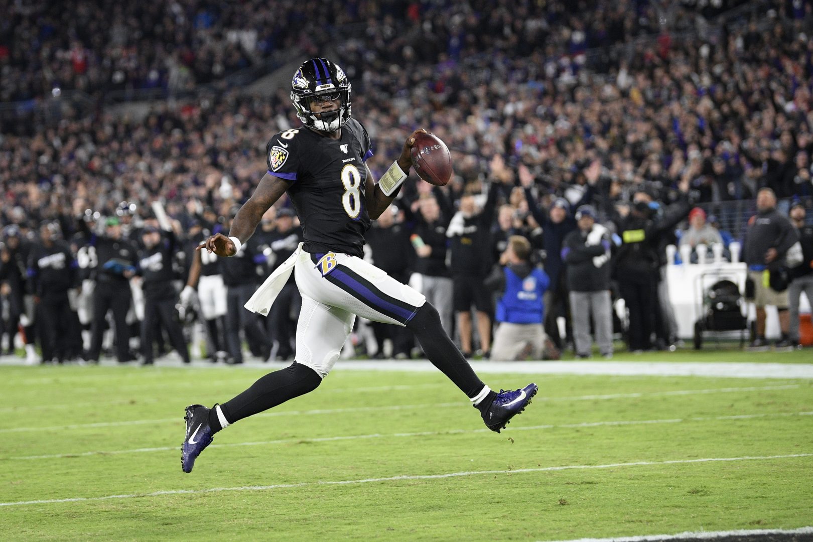 Baltimore Ravens quarterback Lamar Jackson scores on a run against the New England Patriots during the first half of an NFL football game, Sunday, Nov. 3, 2019, in Baltimore.