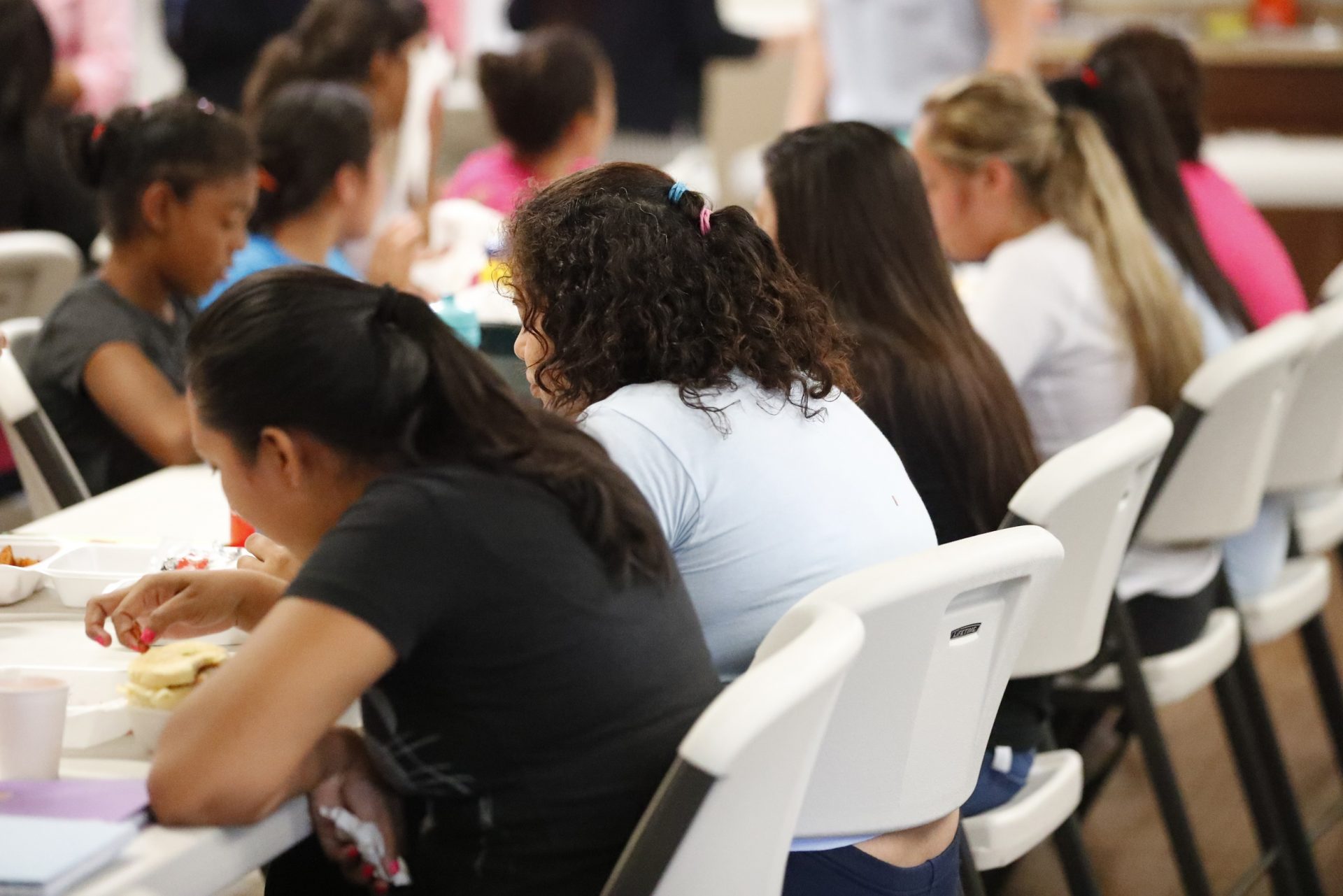 In this Sept. 24, 2019 photo, girls eat lunch at a shelter for migrant teenage girls, in Lake Worth, Fla. The nonprofit U.S. Committee for Refugees and Immigrants opened the federally funded Rinconcito del Sol shelter this summer, aiming to make it a model of excellence in a system of 170 detention centers, residential shelters and foster programs which held nearly 70,000 migrant kids in the past year. 