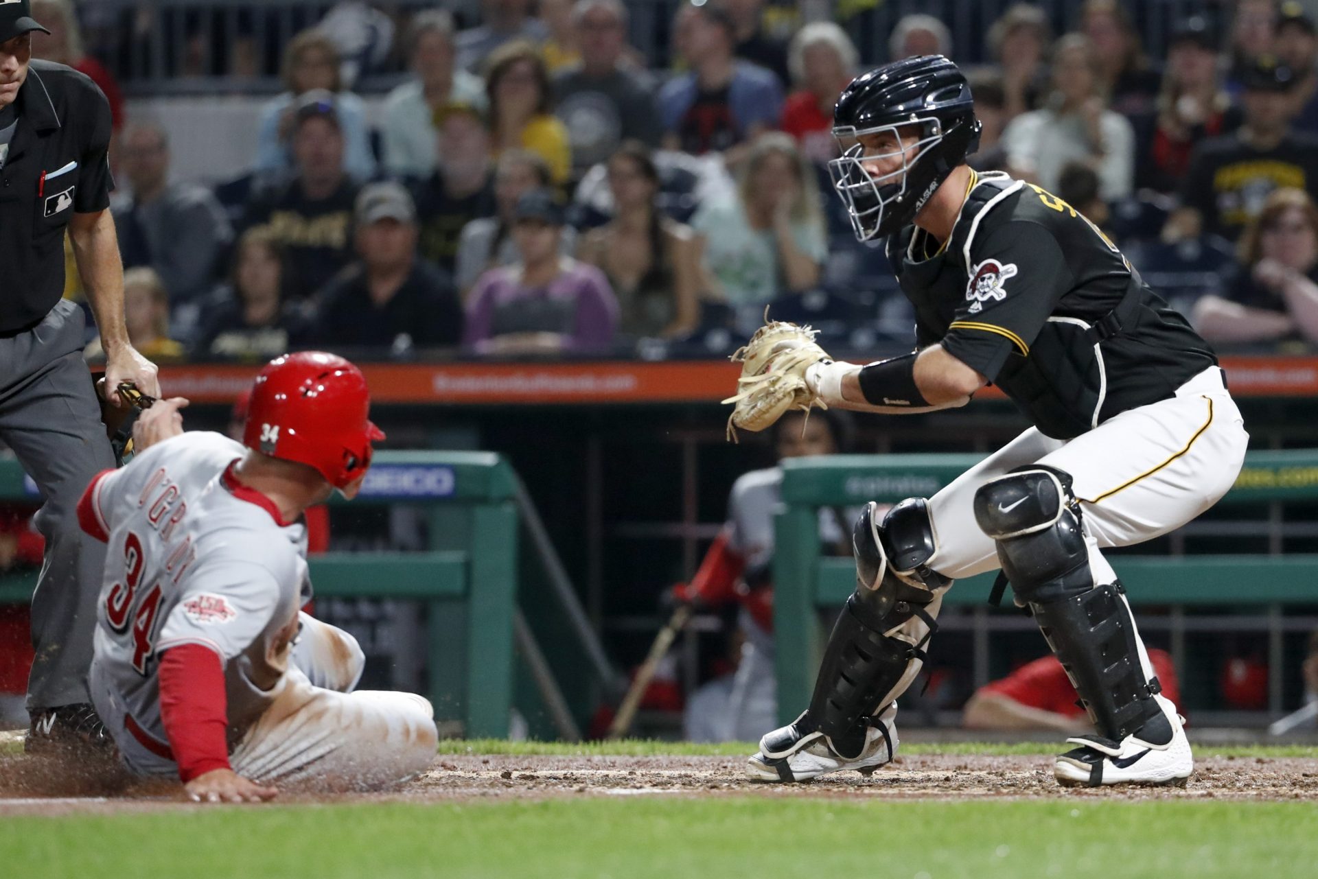 Pittsburgh Pirates catcher Jacob Stallings, right, gets the force out on Cincinnati Reds' Brian O'Grady at home on a bases loaded ground ball by Aristides Aquino in the third inning of a baseball game, Saturday, Sept. 28, 2019, in Pittsburgh.