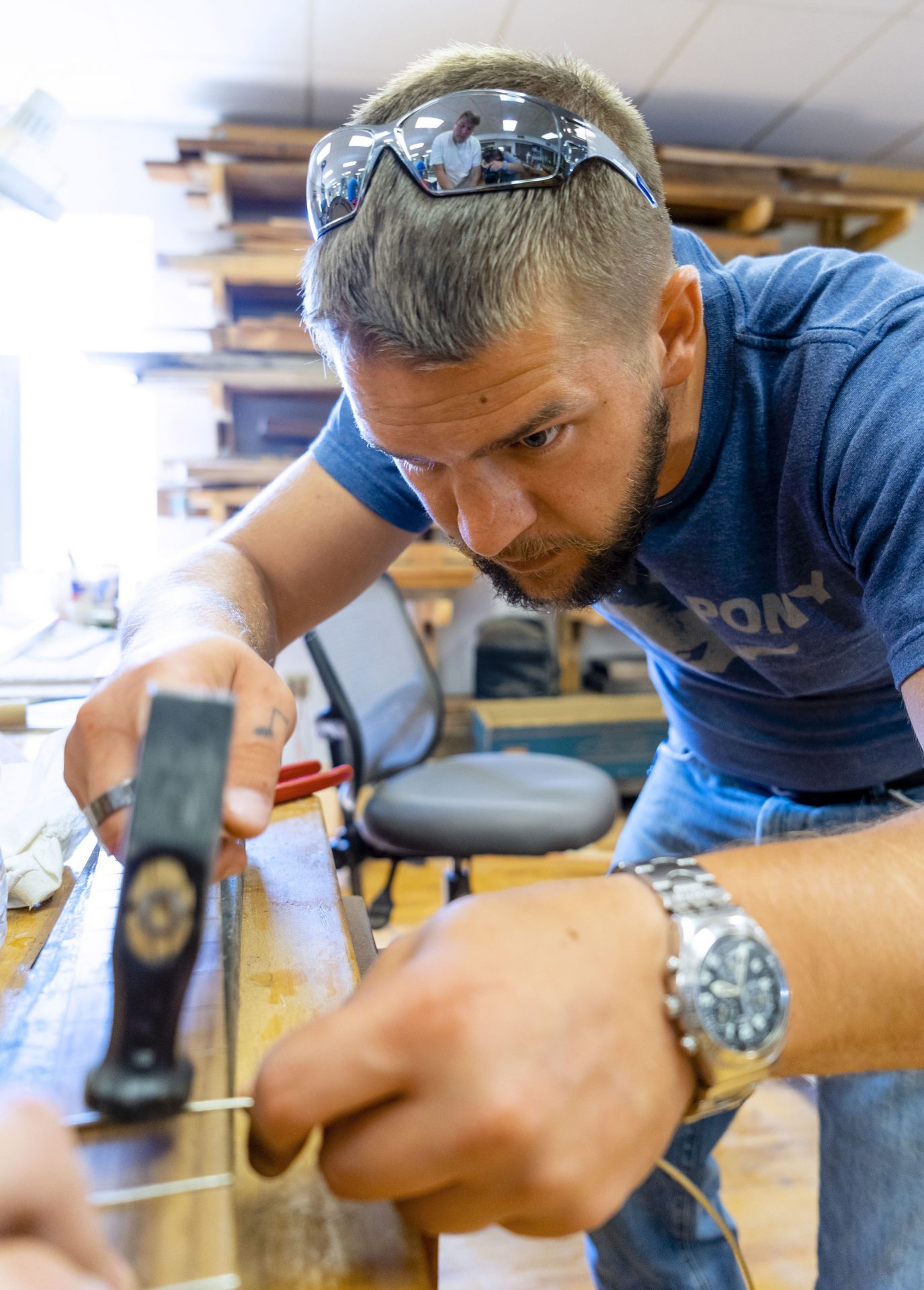 A student from the Culture of Recovery class, Shaun Caudill, hammers in the frets on the fingerboard of his guitar.