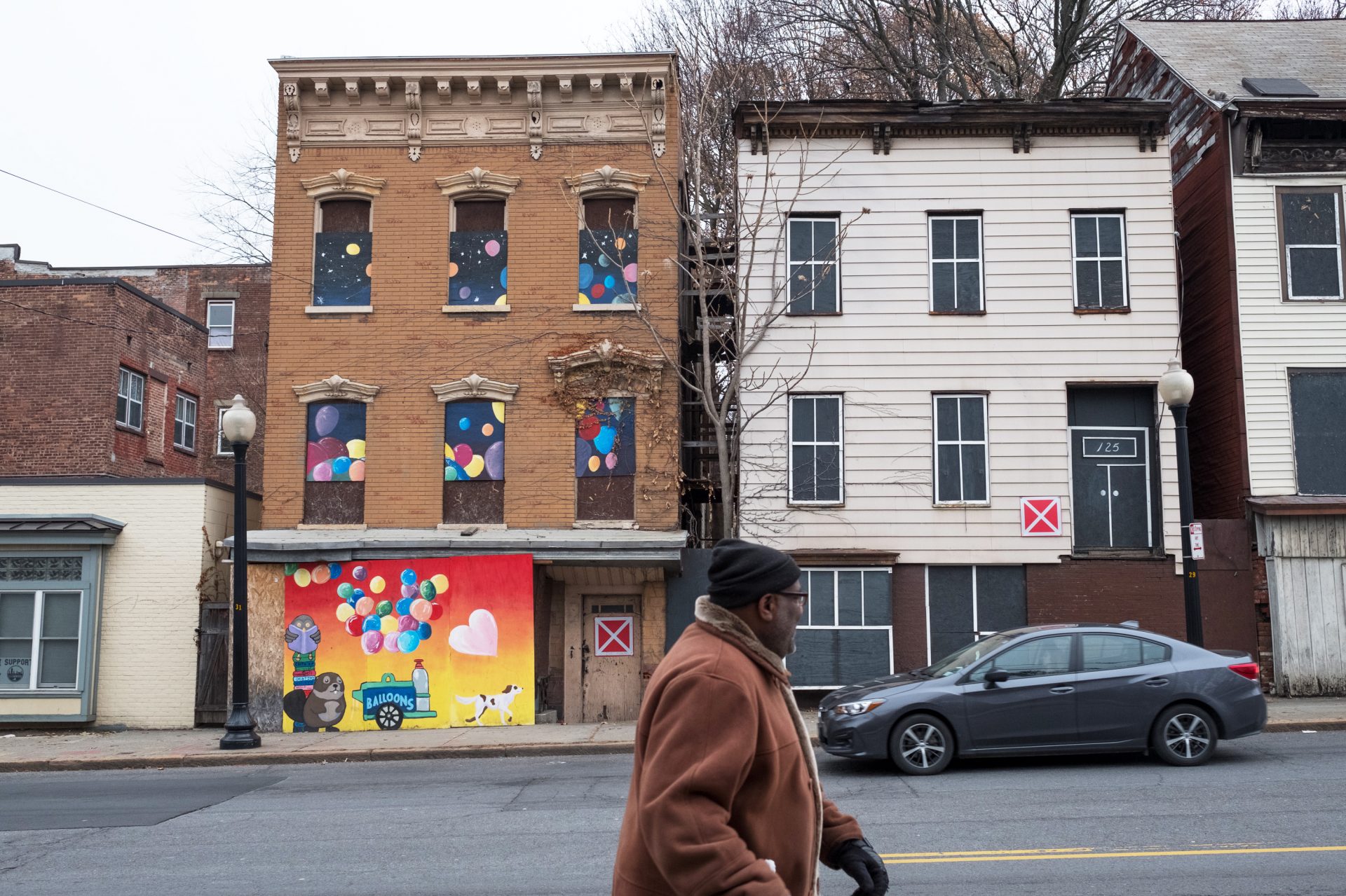 Albany's Arbor Hill neighborhood has many boarded up homes with red signs posted by the fire department. The signs indicate that there is potential the buildings could collapse.