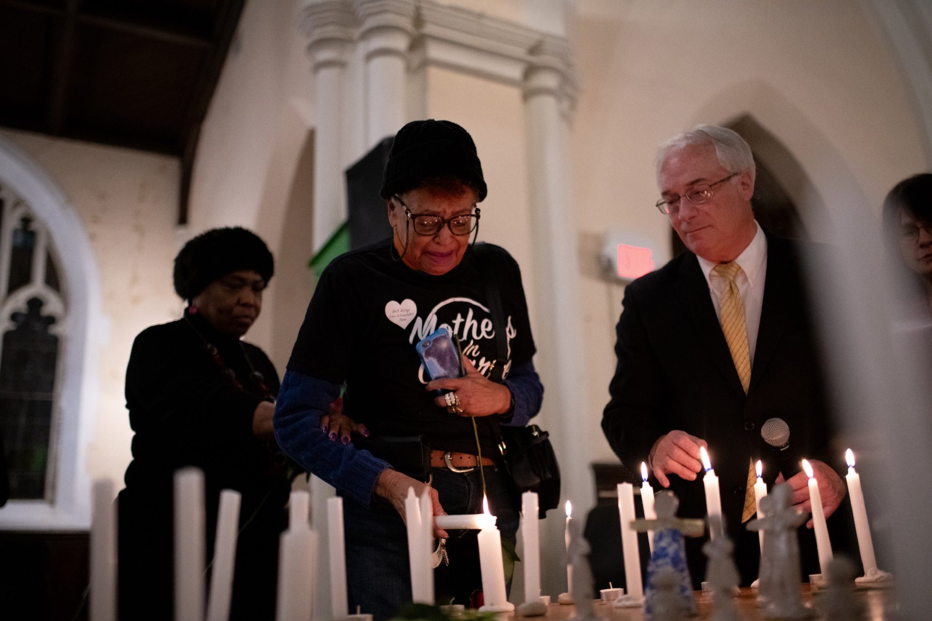 Dr. Patricia Griffin lights a candle for her son, Darien Griffin, and cousin, Gregory Mumford, during a vigil for gun violence victims at Broad Street Ministry on Wednesday, December 11, 2019.