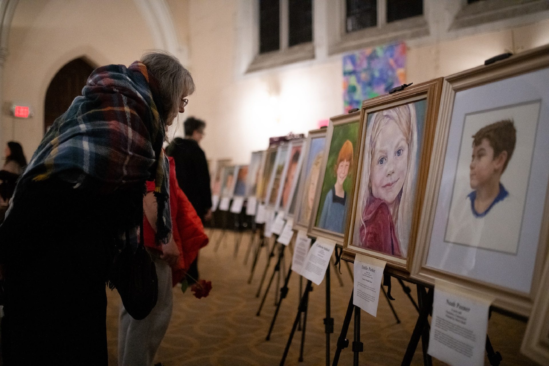 Mourners gathered to remember gun violence victims view portraits of children killed in the Sandy Hook mass shooting following a vigil held at Broad Street Ministry on Wednesday, December 11, 2019. The portraits were created by Lost Dreams on Canvas, an organization that memorials gun violence victims through art.