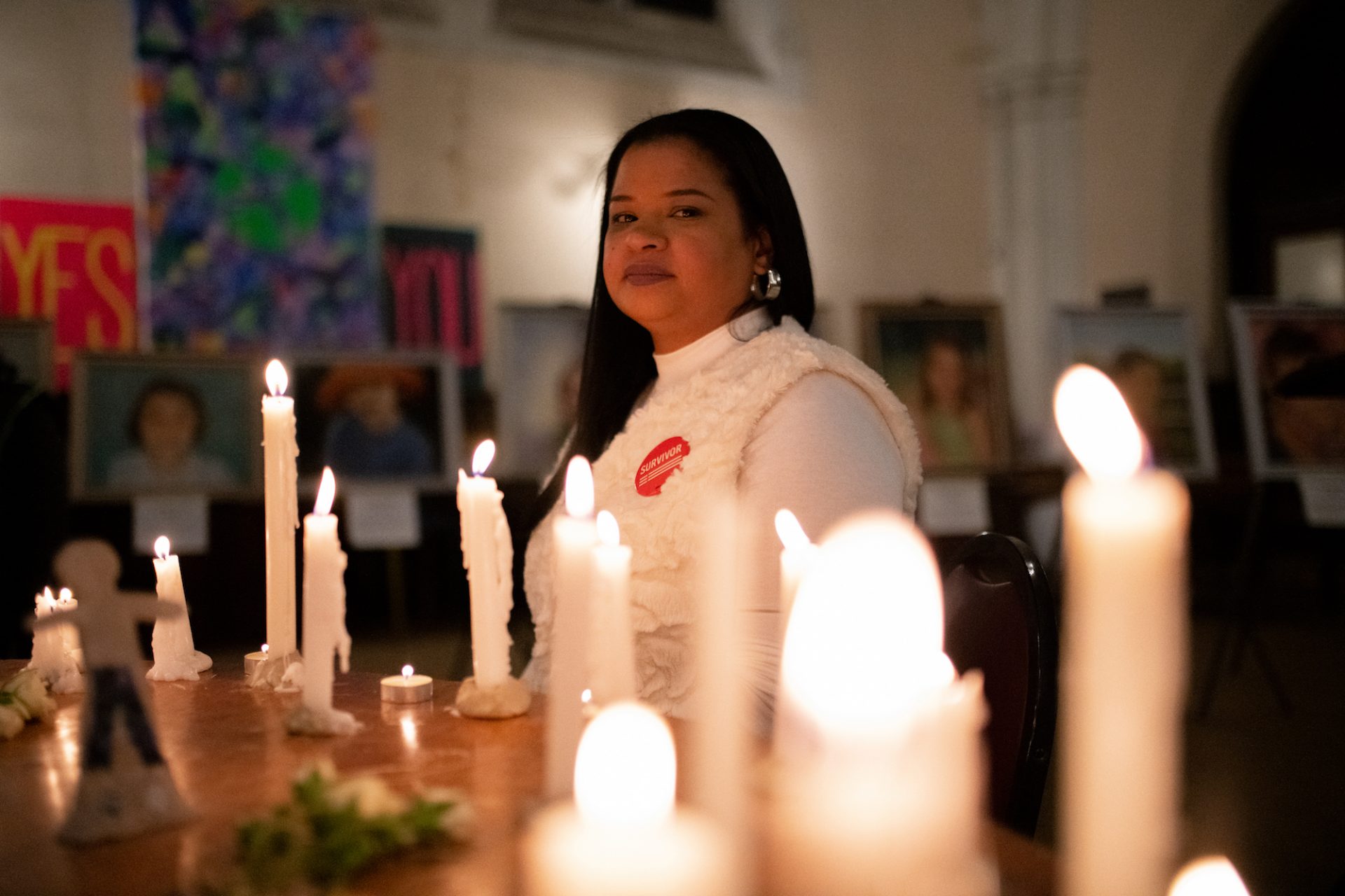Rosalind Pichardo is surrounded by canvas portraits of the Sandy Hook victims and candles lit in remembrance of Philadelphia's own gun violence, after speaking during a vigil held at Broad Street Ministry. Pichardo lost her brother, sister and boyfriend to gun violence, in addition to her father, who took his own life after losing two of his children.