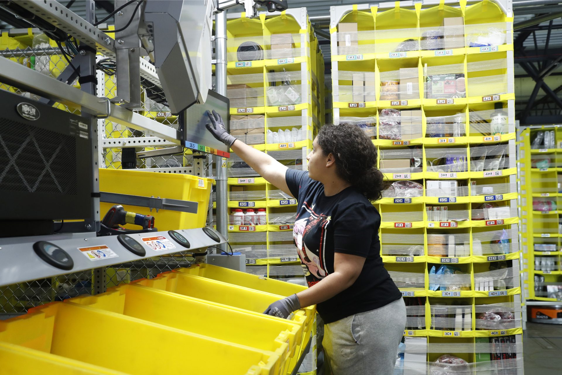 In this June 26, 2019, file photo a worker sorts through items and places orders at the Amazon Fulfillment Center in Staten Island in New York.