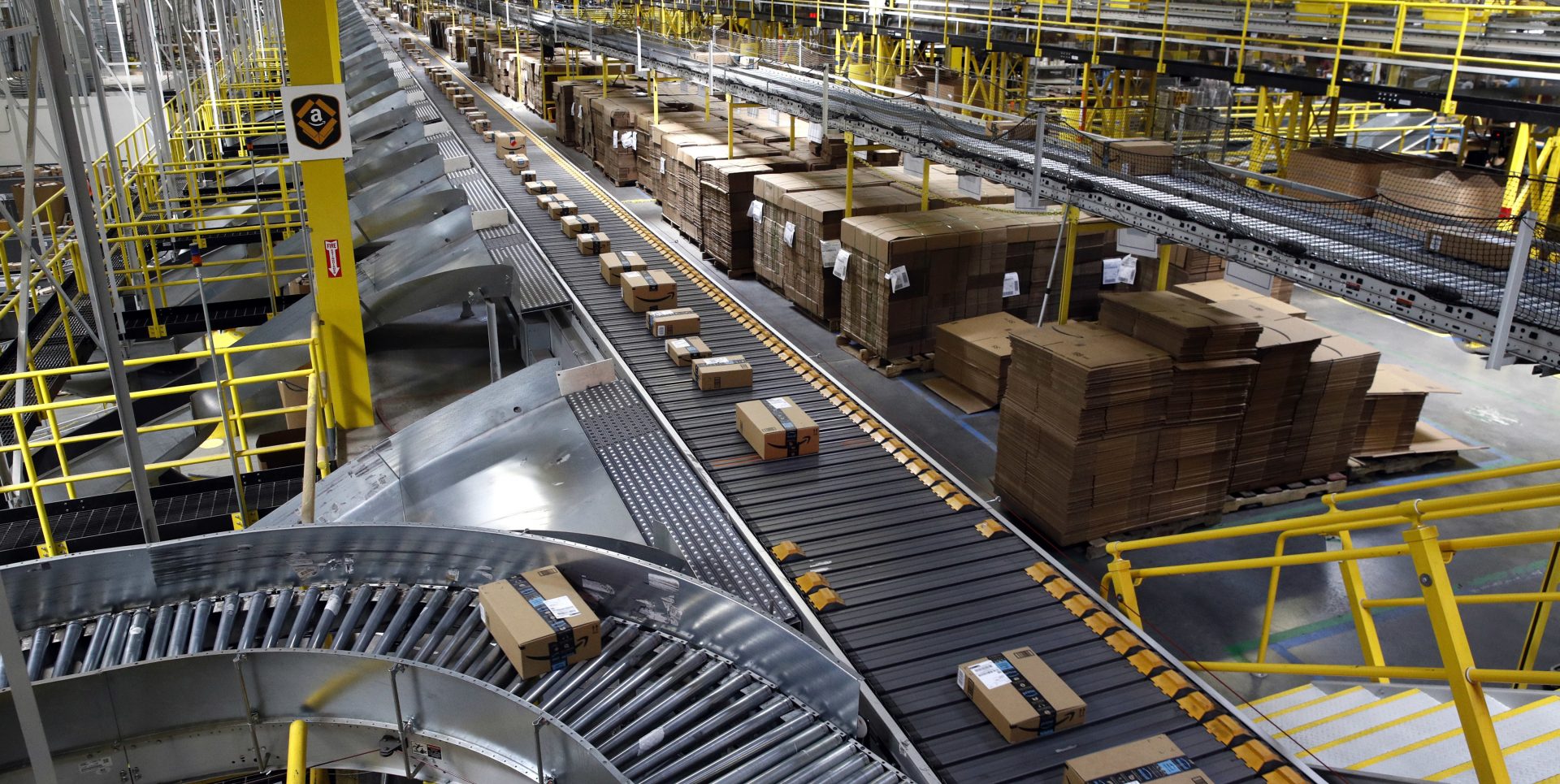 In this Aug. 3, 2017, file photo, packages ride on a conveyor system at an Amazon fulfillment center in Baltimore.
