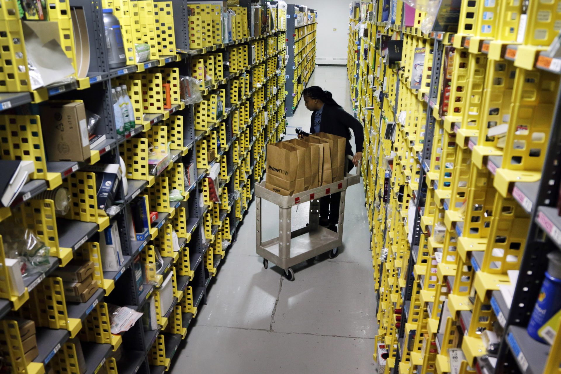 Amazon Prime employee Alicia Jackson hunts for items at the company's urban fulfillment facility that have been ordered by customers, Tuesday, Dec. 22, 2015, in New York.