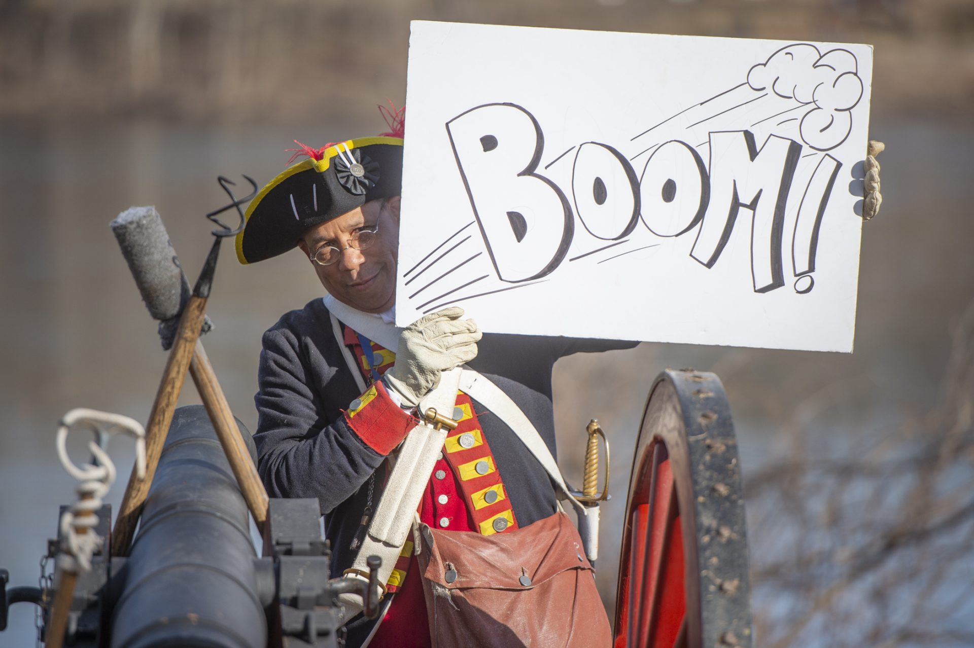 Artilerist Noah Lewis holds a sign aloft for spectators to photograph.