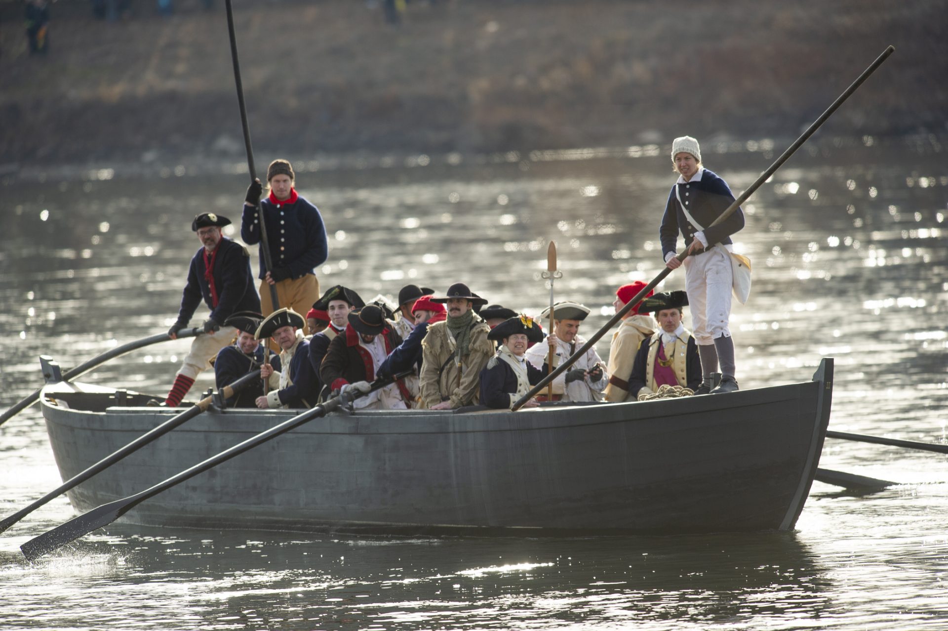 Revolutionary reenactors approach the New Jersey side of the Delaware River in a replica the Durham boat originally used in the crossing.