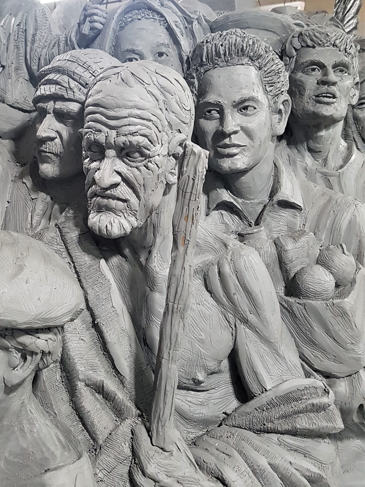 The Italian emigrant behind the man holding the staff carries the bag of bread and fruit — "a metaphor for nourishment," says the sculptor, Timothy Schmalz. In this photo, the sculpture is still in the clay stage, before the bronzing.