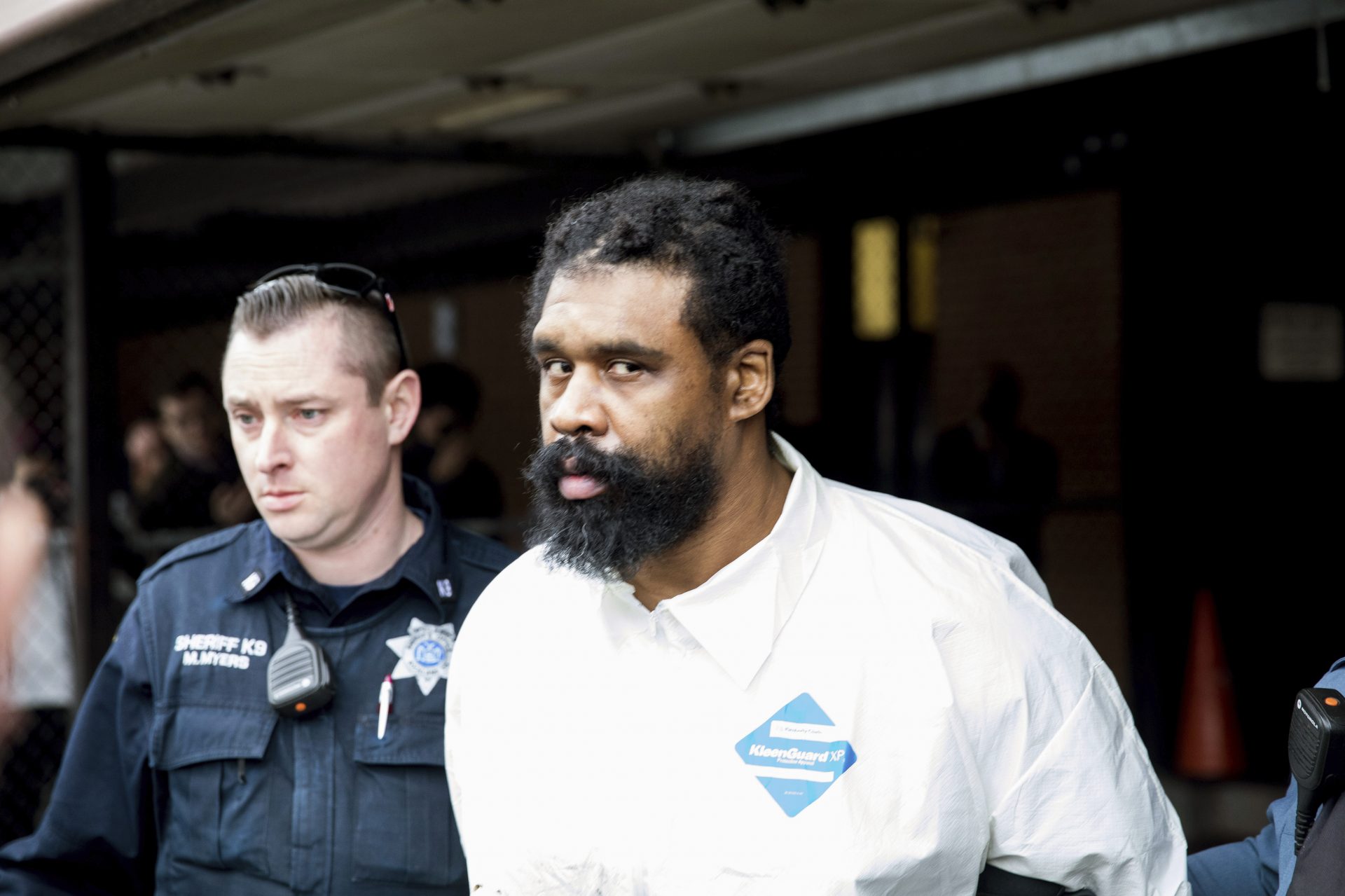 Ramapo police officers escort Grafton Thomas from Ramapo Town Hall to a police vehicle on Sunday. Thomas is accused of stabbing multiple people as they gathered to celebrate Hanukkah at a rabbi's home in the Orthodox Jewish community north of New York City.