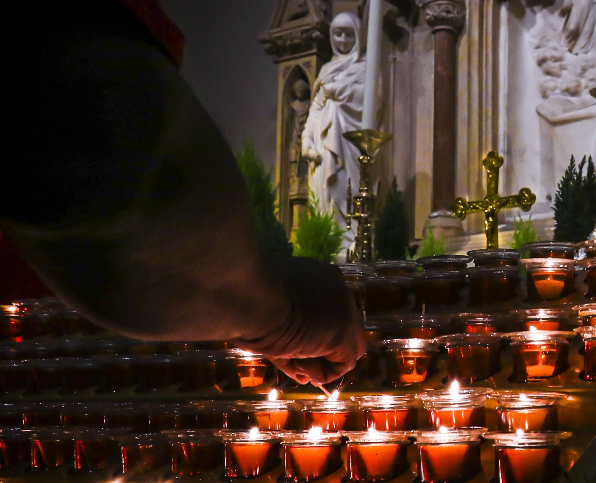 In this Wednesday, Nov. 27, 2019, photo, a Catholic faithful lights candles at a prayer station during a visit to one of the great symbols of the Roman Catholic Church, St. Patrick's Cathedral, in New York. Catholic dioceses are facing a new wave of sexual abuse lawsuits after multiple states extended or suspended the statute of limitations to allow claims stretching back decades. In 2016, New York Archbishop Timothy Dolan established a fund to compensate victims.