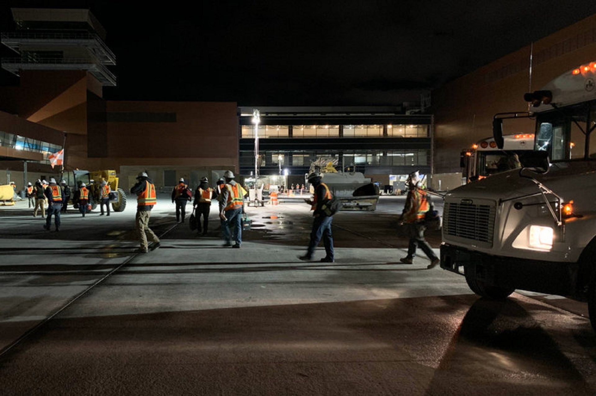 RK workers depart a bus on their way to the job site at a new airport under construction in Salt Lake City.