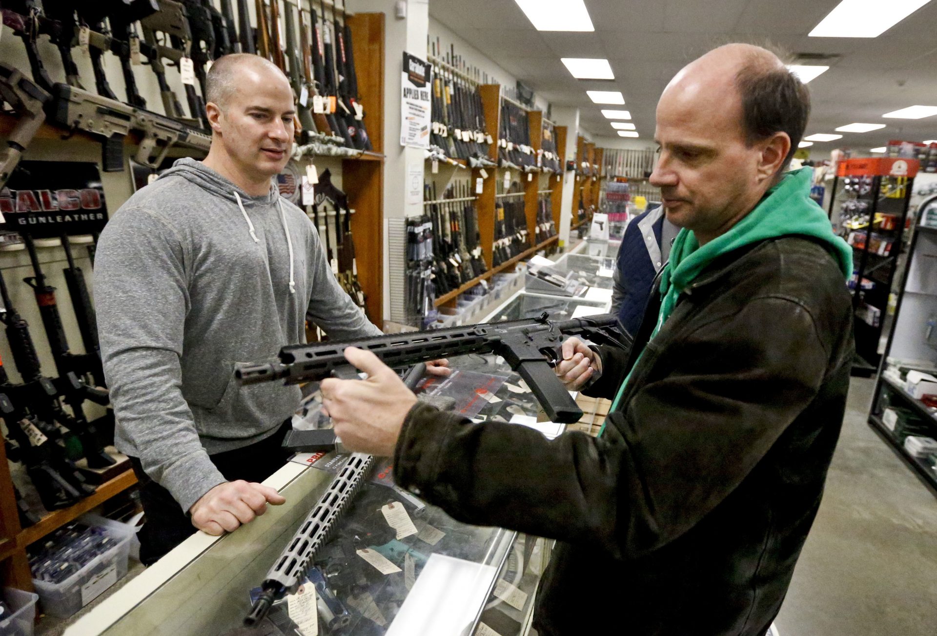 Wes Morosky, owner of Duke's Sport Shop. left, helps Ron Detka as he shops for a rifle on Friday, March 2, 2018, at his store in New Castle. Morosky said business has gone up recently, but that's thanks to the annual infusion of tax refund checks. Sales of firearms slowed dramatically after the election of President Donald Trump in 2016 allayed fears of a Democratic crackdown on gun owners. That trend continues, even with talk of gun control in Congress following the massacre of 17 people at a Florida high school last month.