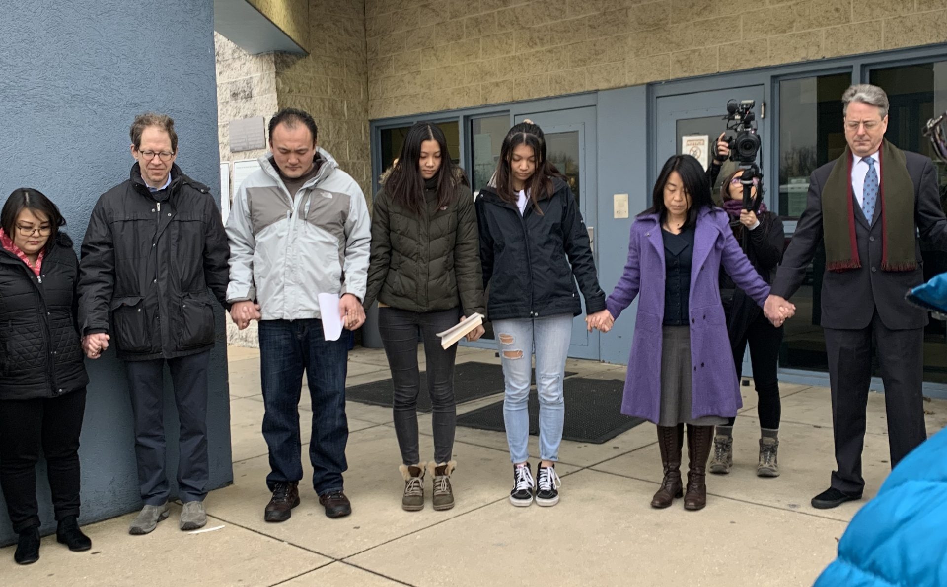 The daughters and supporters gather in a prayer circle after the hearing.