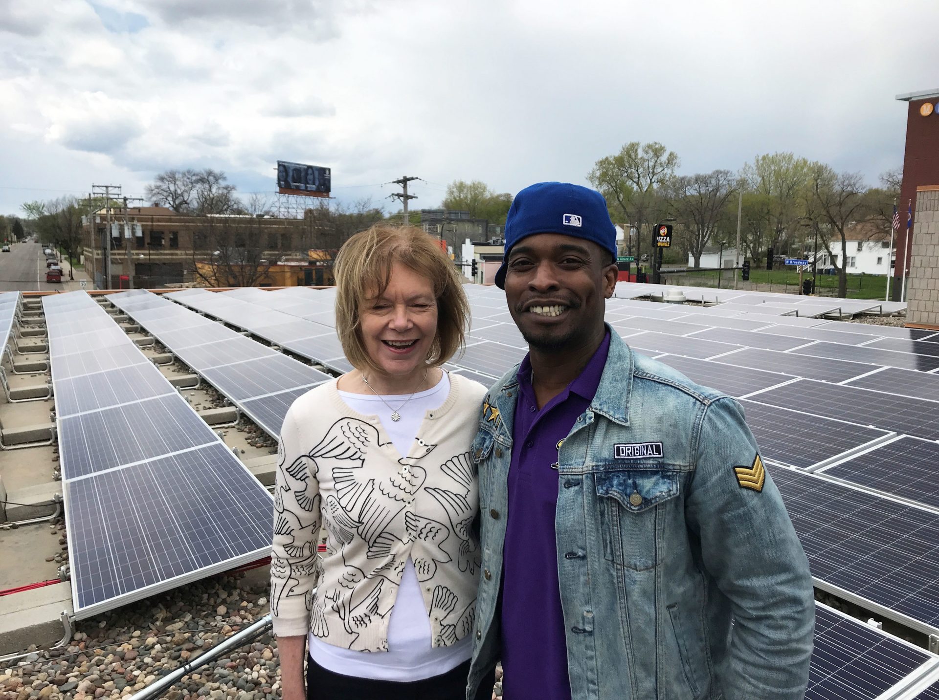 Sen. Tina Smith, D-Minn., and Keith Dent stand in front of the community solar garden on the roof of Shiloh Temple in Minneapolis. Dent helped install the array.