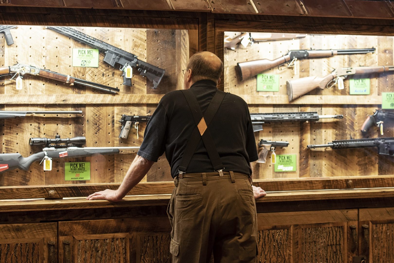 In this April 25, 2019, file photo, a man looks at cases of firearms in the halls of the Indianapolis Convention Center where the National Rifle Association will be holding its 148th annual meeting in Indianapolis. 