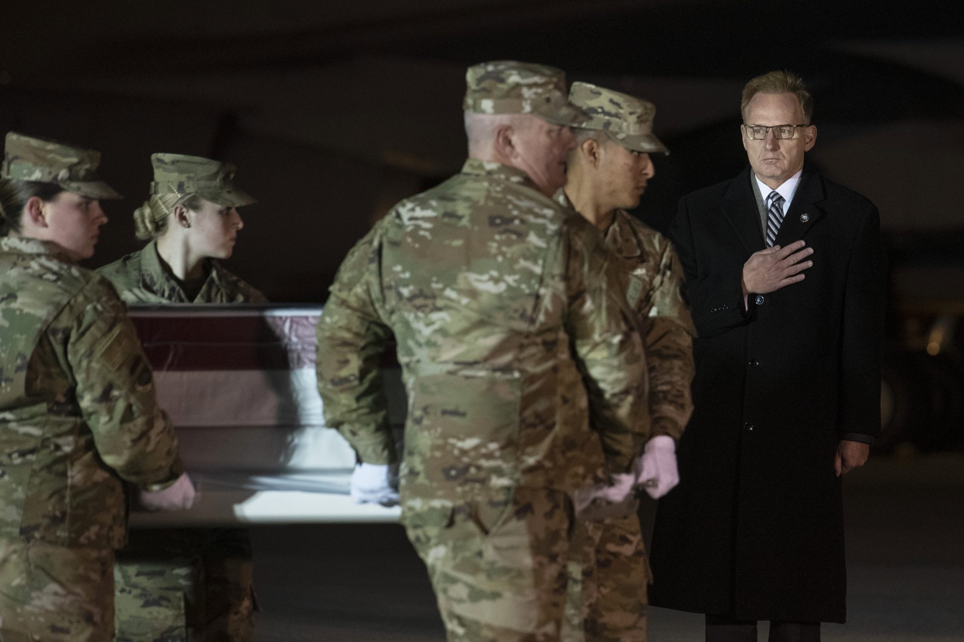 Acting Navy Secretary Thomas Modly, right, looks on as an Air Force carry team moves a transfer case containing the remains of Navy Ensign Joshua Watson on Sunday, Dec. 8, 2019, at Dover Air Force Base, Del. A Saudi gunman killed three people including 23-year-old Watson, a recent graduate of the U.S. Naval Academy from Enterprise, Ala., in a shooting at Naval Air Station Pensacola in Florida.