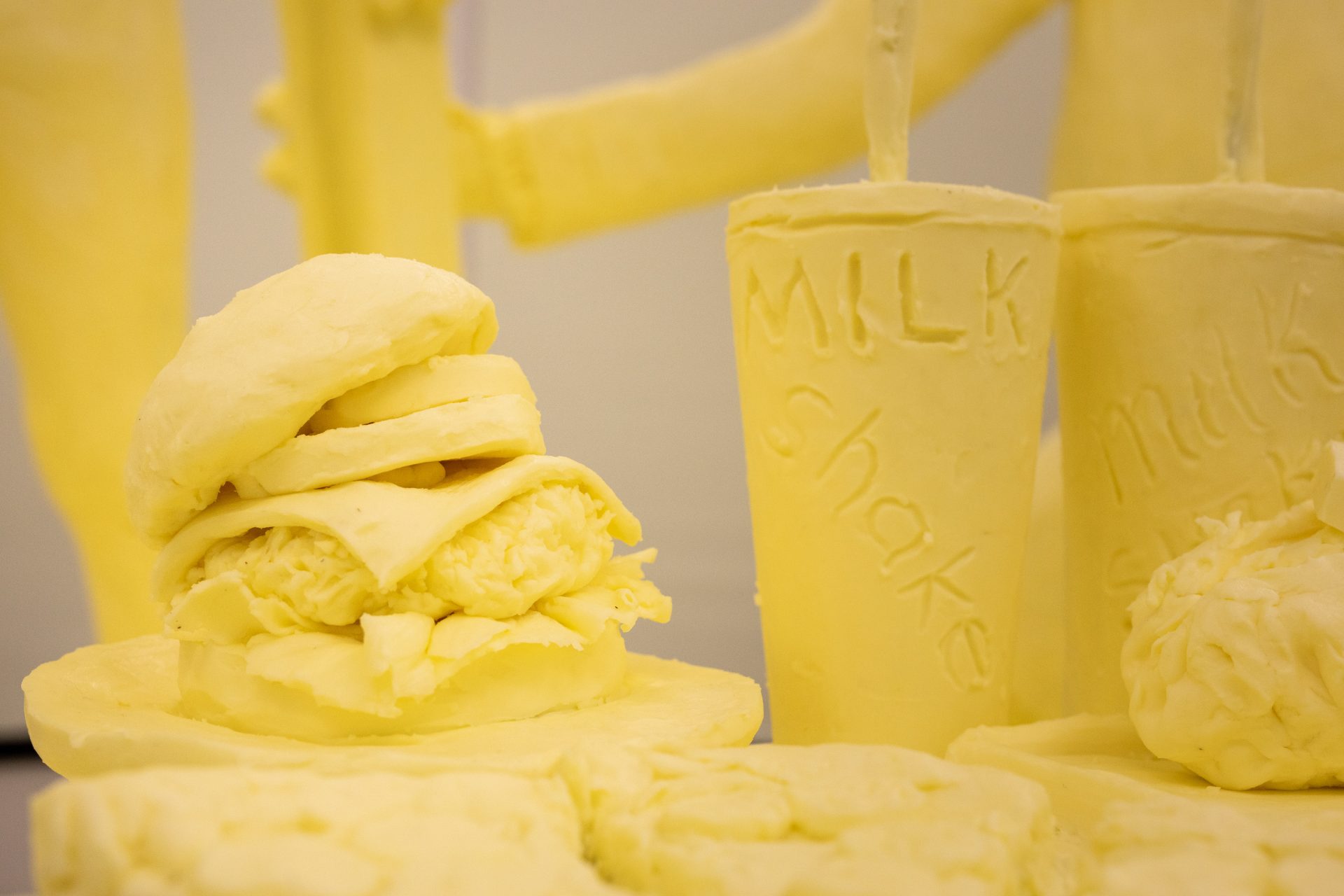 The tailgating-themed 2020 Pennsylvania Farm Show butter sculpture features a spread of dairy products, including a cheeseburger, pizza and milkshakes.