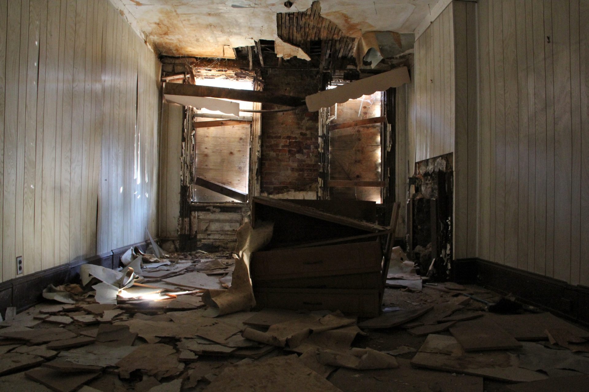 Shafts of light penetrate the boarded windows in the living room of 753 Walnut St. on Feb. 3, 2015.