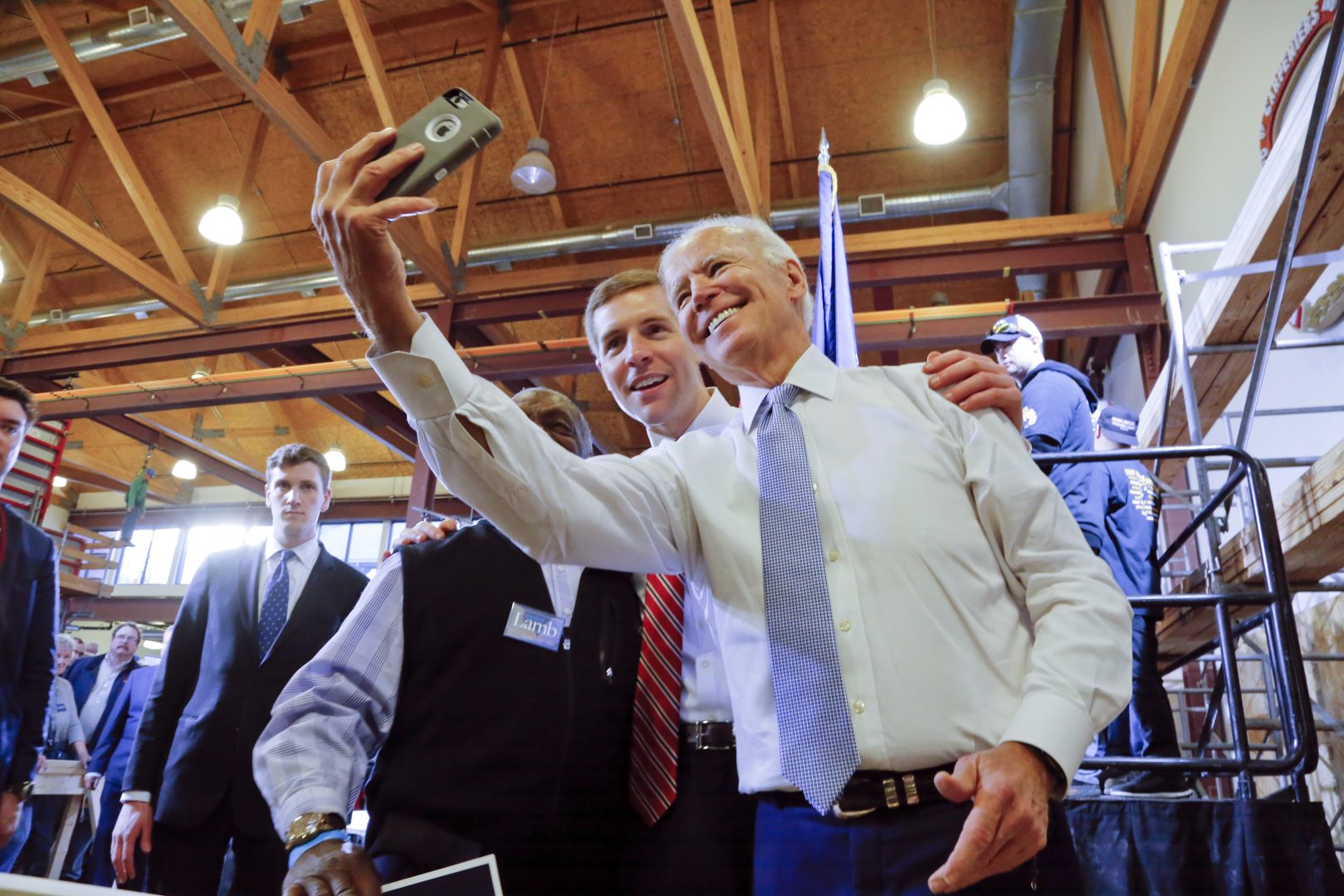 FILE PHOTO: Conor Lamb, center, then a Democratic candidate for the March 13 special election in Pennsylvania's 18th Congressional District, and former Vice President Joe Biden, right, pose for a selfie with a supporter during a rally at the Carpenter's Training Center in Collier, Pa., Tuesday, March 6, 2018.
