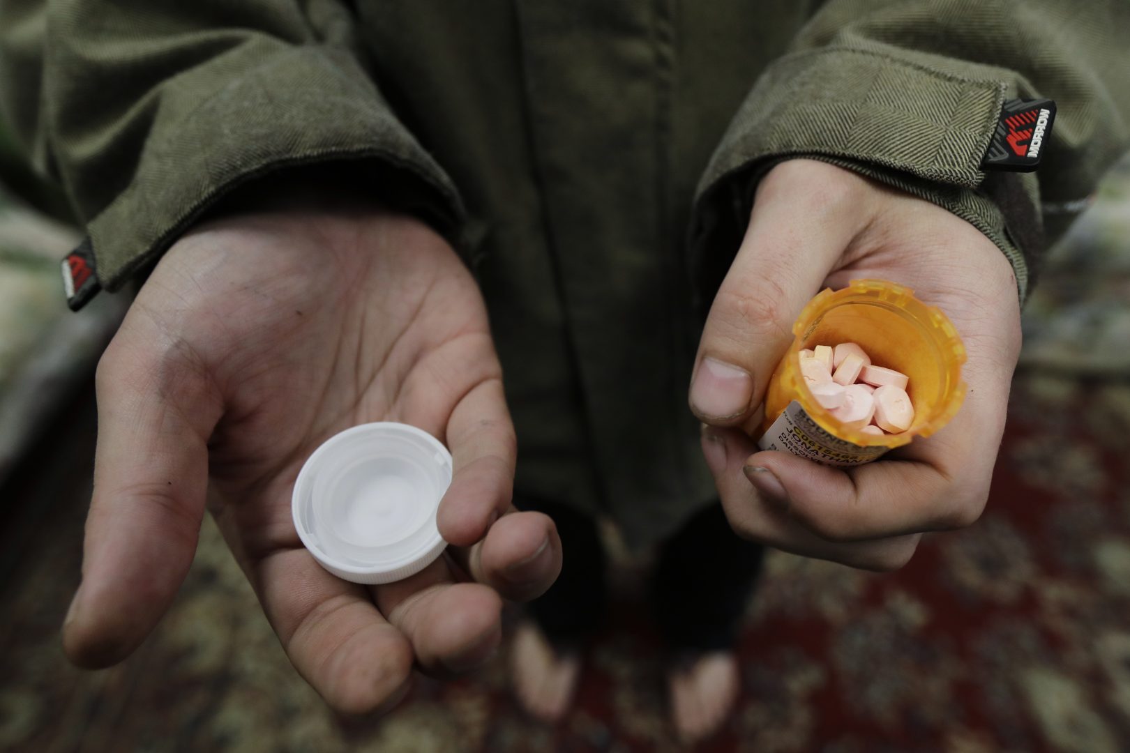 In this Nov. 14, 2019 photo, Jon Combes holds his bottle of buprenorphine, a medicine that prevents withdrawal sickness in people trying to stop using opiates, as he prepares to take a dose in a clinic in Olympia, Wash. The clinic is working to spread a philosophy called 