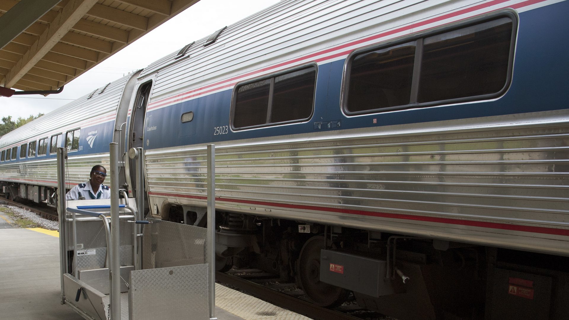 A member of the station staff pushes a portable wheelchair lift along the platform at an Amtrak station in DeLand, Fla. The company says its policies for having to adjust or remove seats has changed.