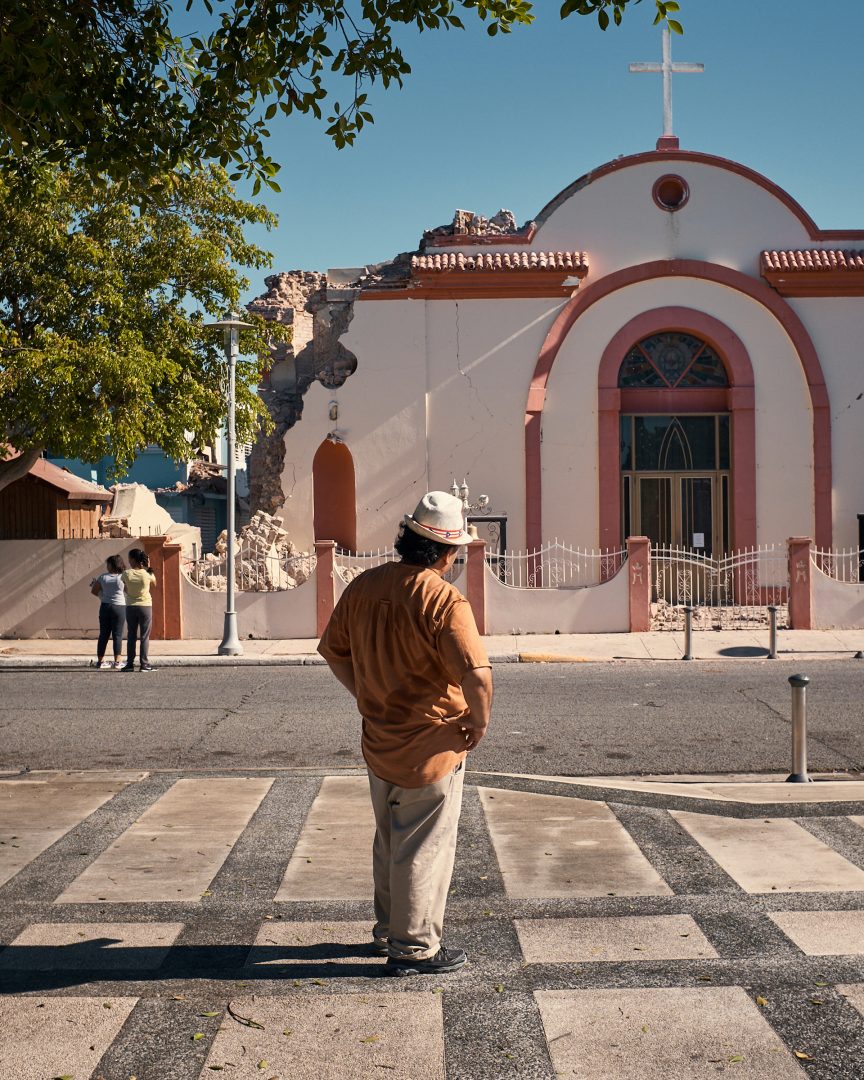 A man stands in front of a church that was damaged in an earthquake on Monday in Guayanilla, Puerto Rico.
