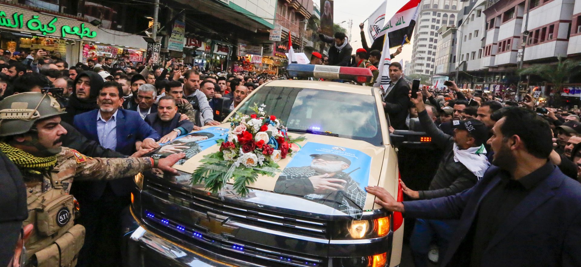 Mourners surround a vehicle carrying the coffins of Iranian Maj. Gen. Qassem Soleimani and Iraqi militia leader Abu Mahdi al-Muhandis, during a funeral procession Saturday in Baghdad.
