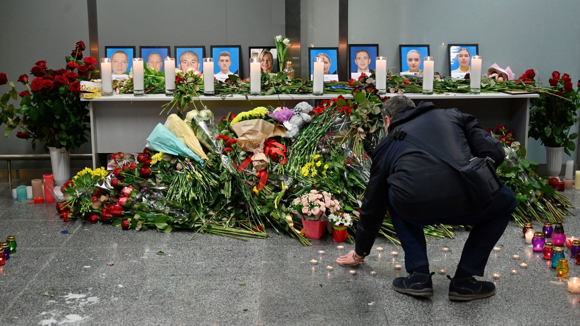 A man lays his remembrance before a memorial for the crash victims, set up Wednesday at the airport outside Ukraine's capital, Kyiv. Among the 176 victims aboard the plane were 82 Iranians, 63 Canadians and 11 Ukrainians.