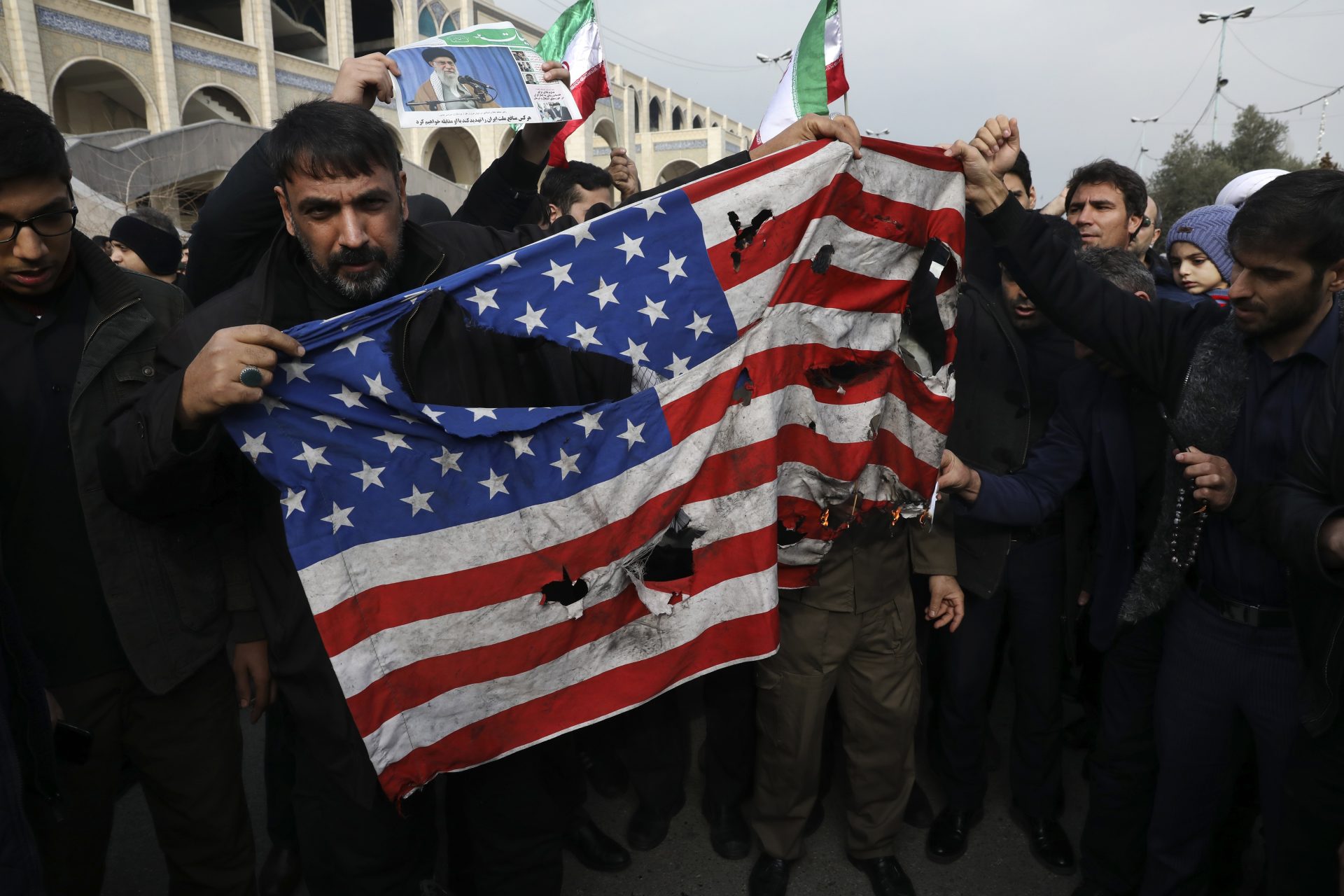 Protesters burn a U.S. flag during a demonstration over the U.S. airstrike in Iraq that killed Iranian Revolutionary Guard Gen. Qassem Soleimani, in Tehran, Iran, Jan. 3, 2020. Iran has vowed "harsh retaliation" for the U.S. airstrike near Baghdad's airport that killed Tehran's top general and the architect of its interventions across the Middle East, as tensions soared in the wake of the targeted killing.