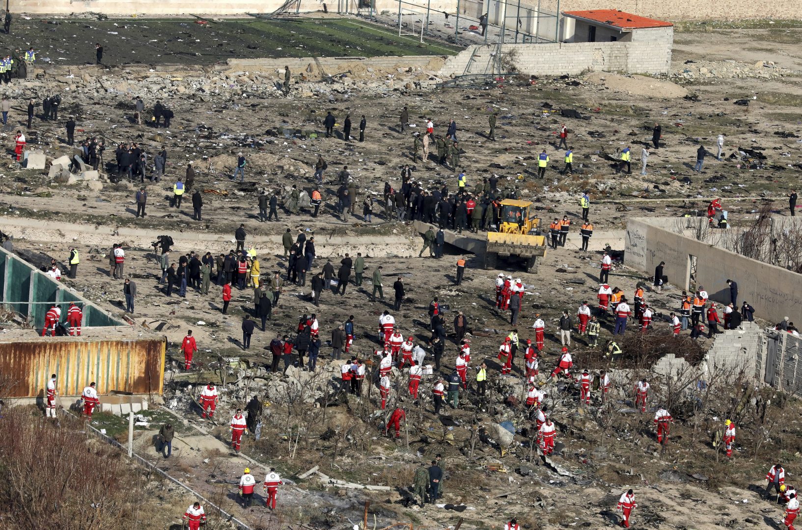 Rescue workers search the scene where an Ukrainian plane crashed in Shahedshahr, southwest of the capital Tehran, Iran, Wednesday, Jan. 8, 2020. A Ukrainian passenger jet carrying 176 people crashed on Wednesday, just minutes after taking off from the Iranian capital's main airport, turning farmland on the outskirts of Tehran into fields of flaming debris and killing all on board. 