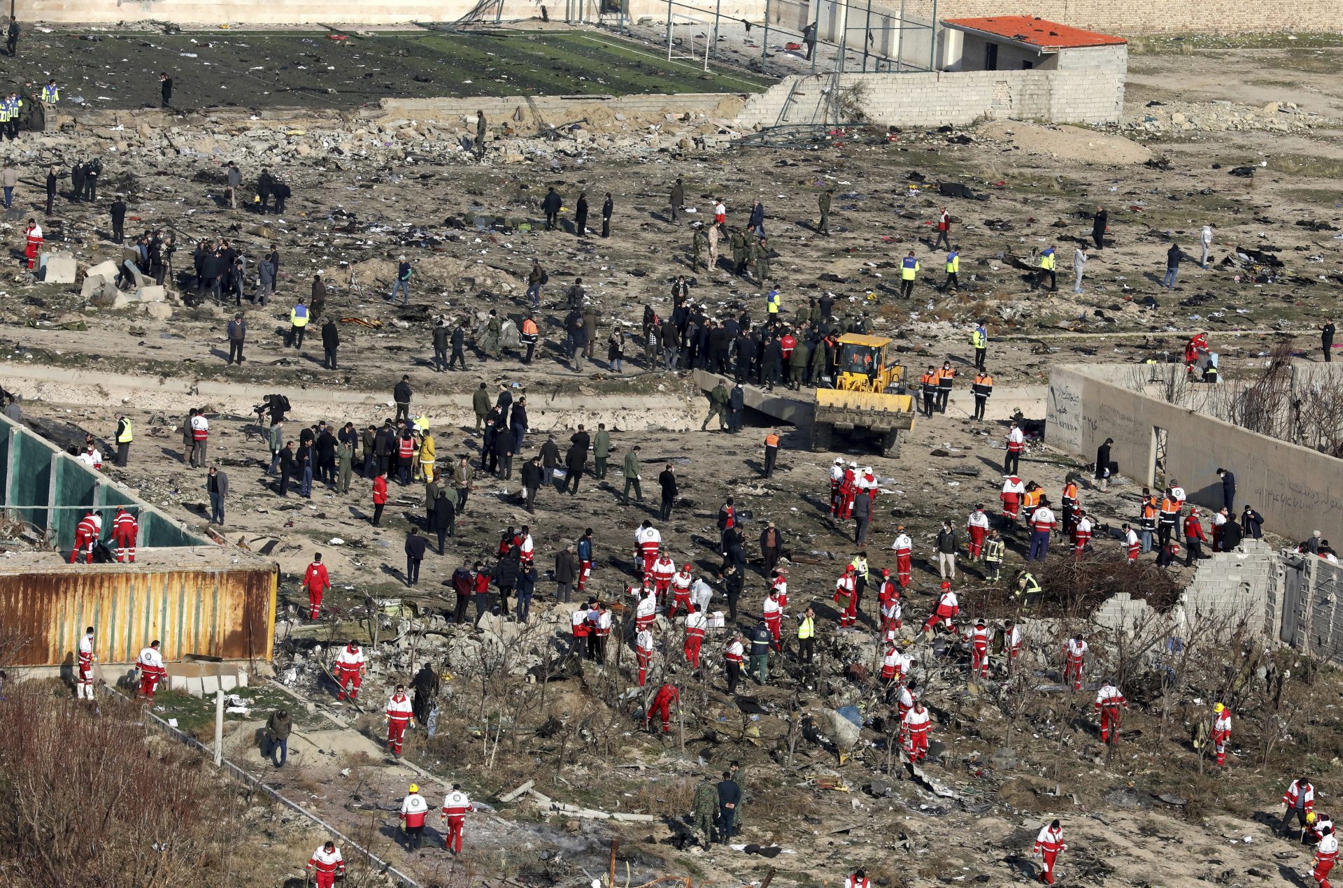 Rescue workers search the scene where an Ukrainian plane crashed in Shahedshahr, southwest of the capital Tehran, Iran, Wednesday, Jan. 8, 2020. A Ukrainian passenger jet carrying 176 people crashed on Wednesday, just minutes after taking off from the Iranian capital's main airport, turning farmland on the outskirts of Tehran into fields of flaming debris and killing all on board.