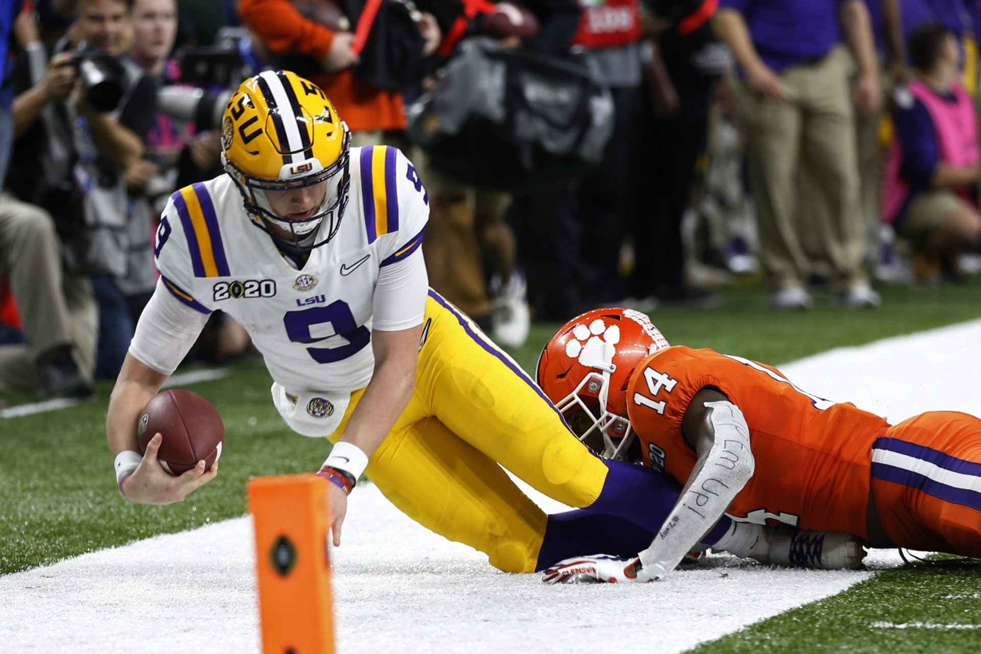 LSU quarterback Joe Burrow is tackled by LSU defensive back Maurice Hampton Jr. during the first half of a NCAA College Football Playoff national championship game Monday, Jan. 13, 2020, in New Orleans.