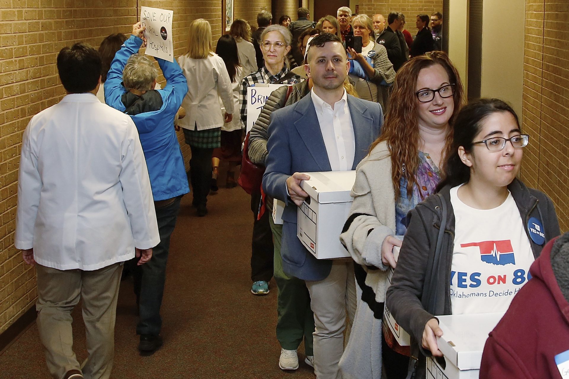 Supporters of Yes on 802 Oklahomans Decide Healthcare, calling for Medicaid expansion to be put on the ballot, carry boxes of petitions into the office of the Oklahoma Secretary of State, Thursday, Oct. 24, 2019, in Oklahoma City. The signatures of about 178,000 registered voters are needed to get the question on the ballot, and supporters say they obtained about 313,000 signatures.