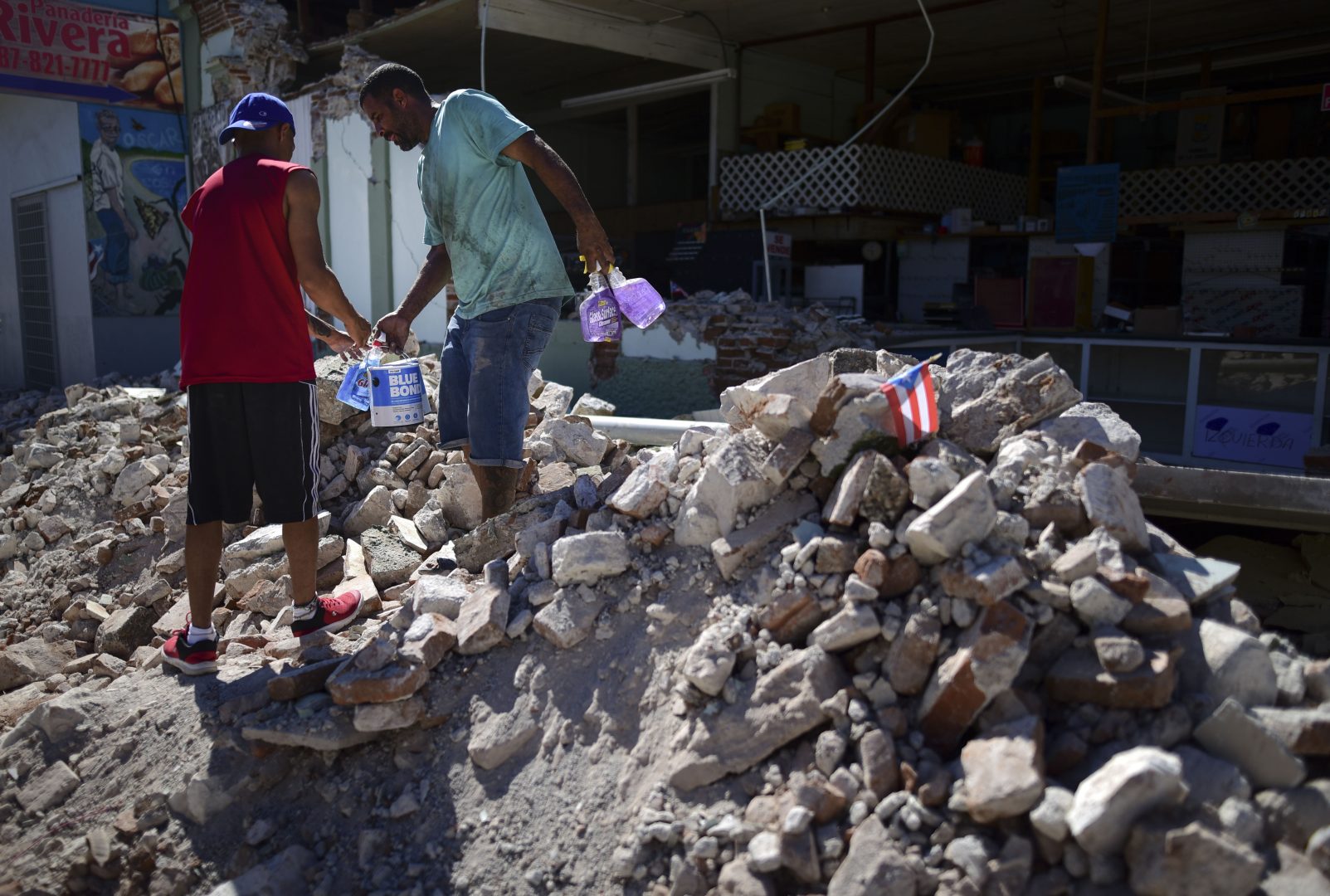 Store owners and family help remove supplies from Ely Mer Mar hardware store, which partially collapsed after an earthquake struck Guanica, Puerto Rico, Tuesday, Jan. 7, 2020. A 6.4-magnitude earthquake struck Puerto Rico before dawn on Tuesday, killing one man, injuring others and collapsing buildings in the southern part of the island. 