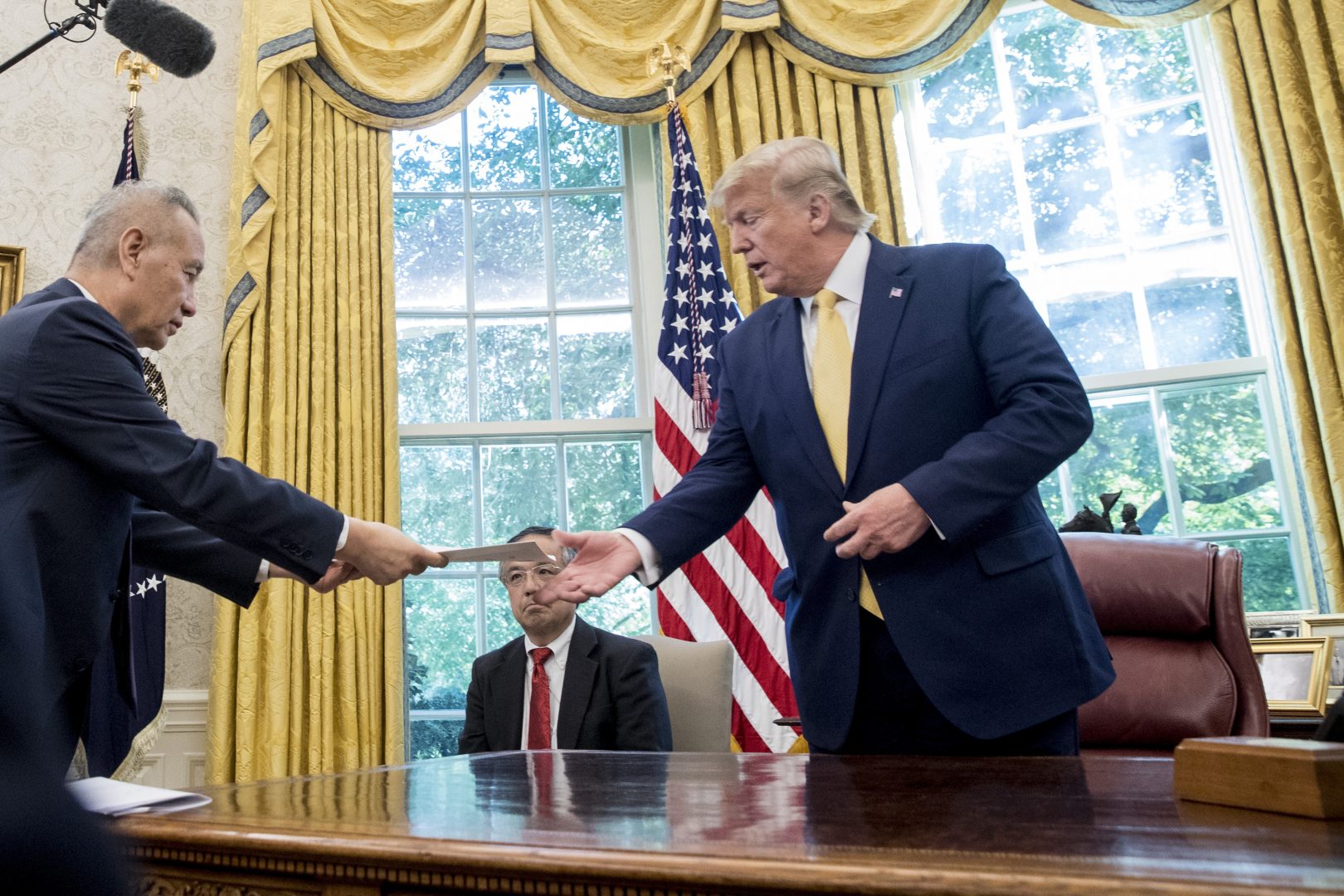 President Donald Trump receives a letter presented to him by Chinese Vice Premier Liu He, left, in the Oval Office of the White House in Washington, Friday, Oct. 11, 2019.