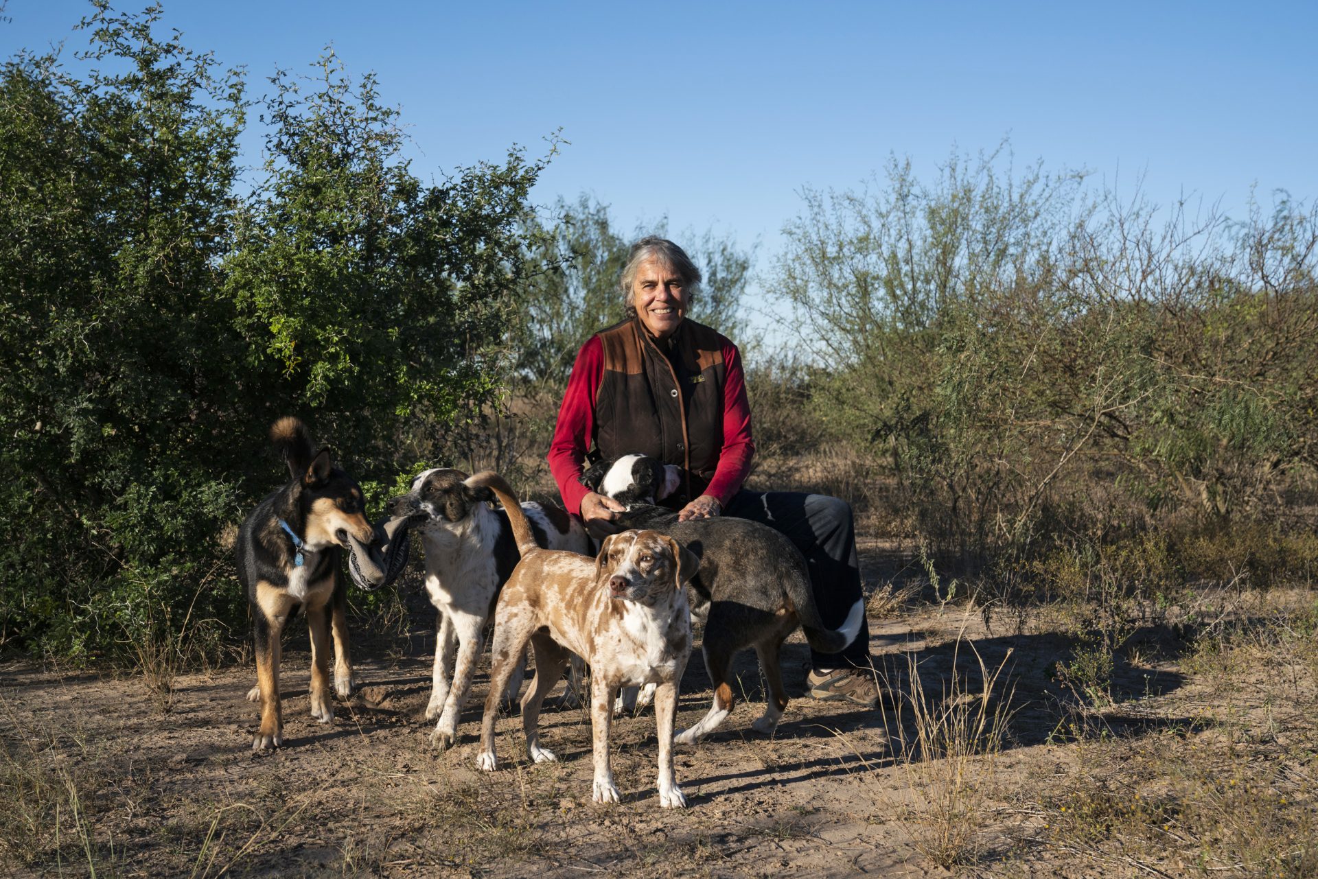 Betty Perez poses with her dogs in an area on her ranch that she is designating as a wildlife corridor. She is past president of the Friends of the Wildlife Corridor, which is adamantly opposed to the border wall.