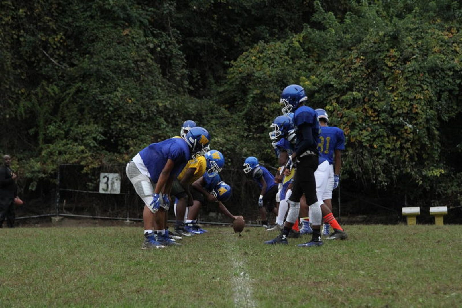 Westinghouse High School football players line up for a practice play in Homewood. The school was the first in Pittsburgh to implement a Coaching Boys into Men program.