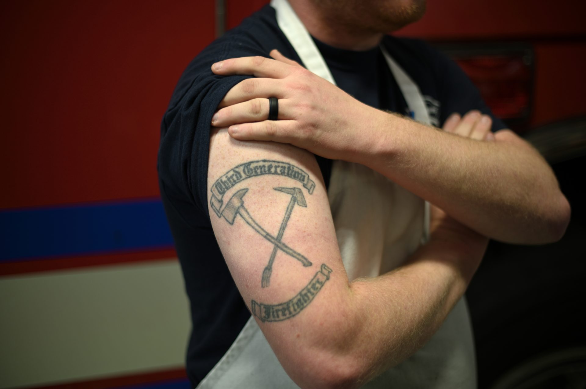 Third generation firefighter AJ Alves, 25 shows his tattoo as he poses for a photo at Humane Fire Co., in Pottsville, PA, on December 15, 2019.