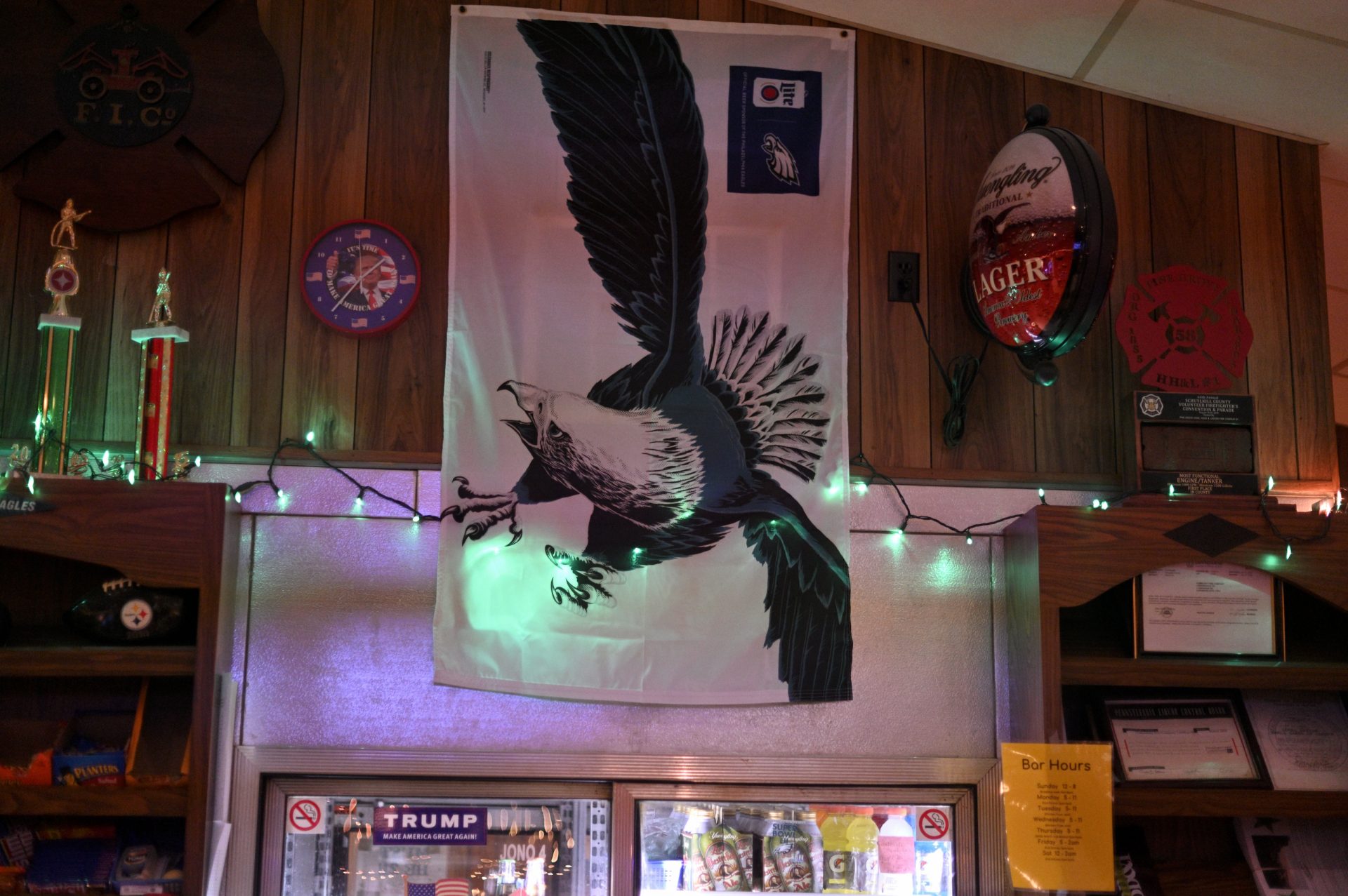 A sticker and clock in suport of President Donald Trump, as well as a large Eagles flag are found behind the bar of the Social Quarters of the Landingville Community Fire Company, in Landingville, PA, on December 15, 2019.