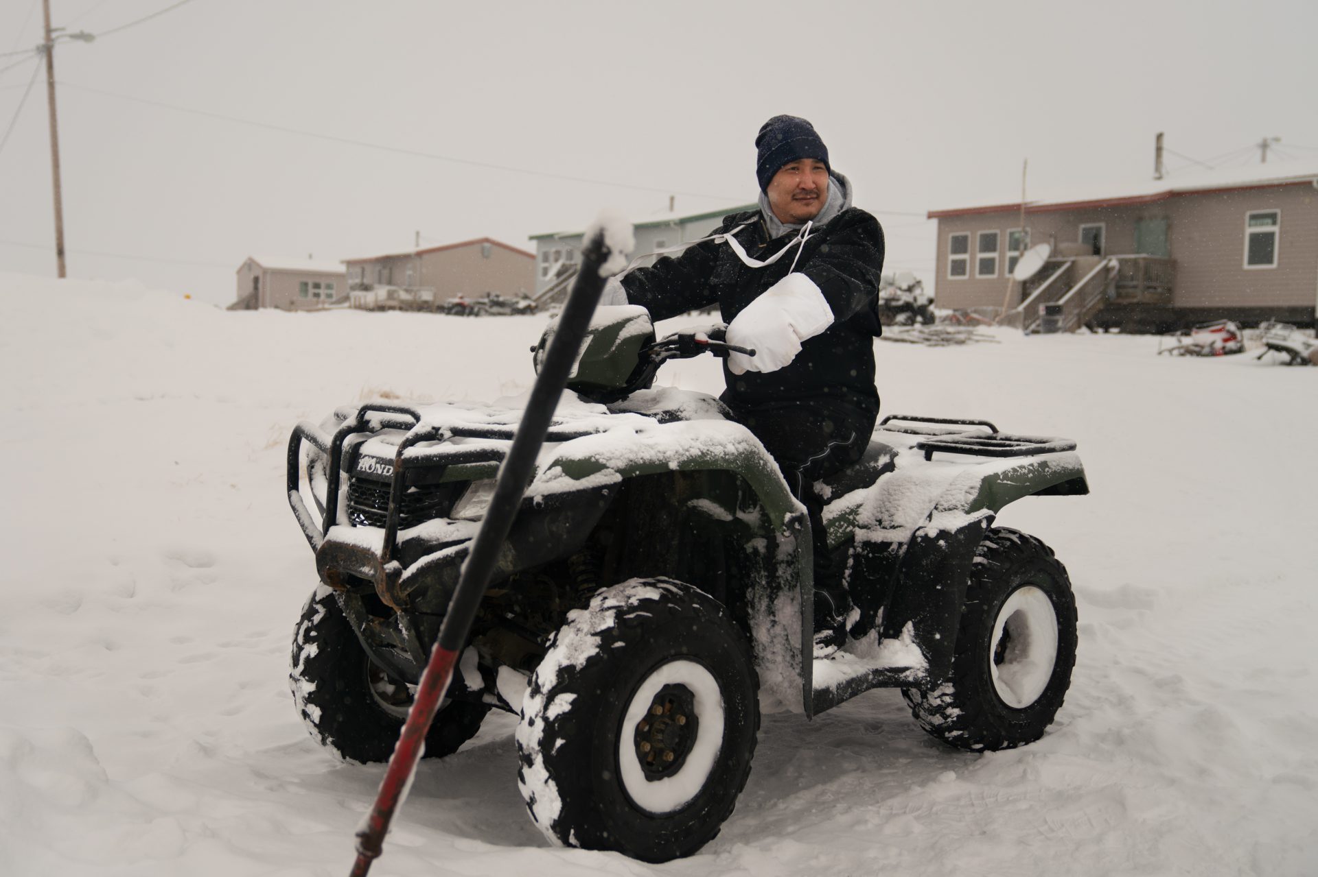 Noah Lincoln, a subsistence hunter and assistant coach for the local high school boys' basketball team, sits on his ATV outside his home in Toksook Bay.