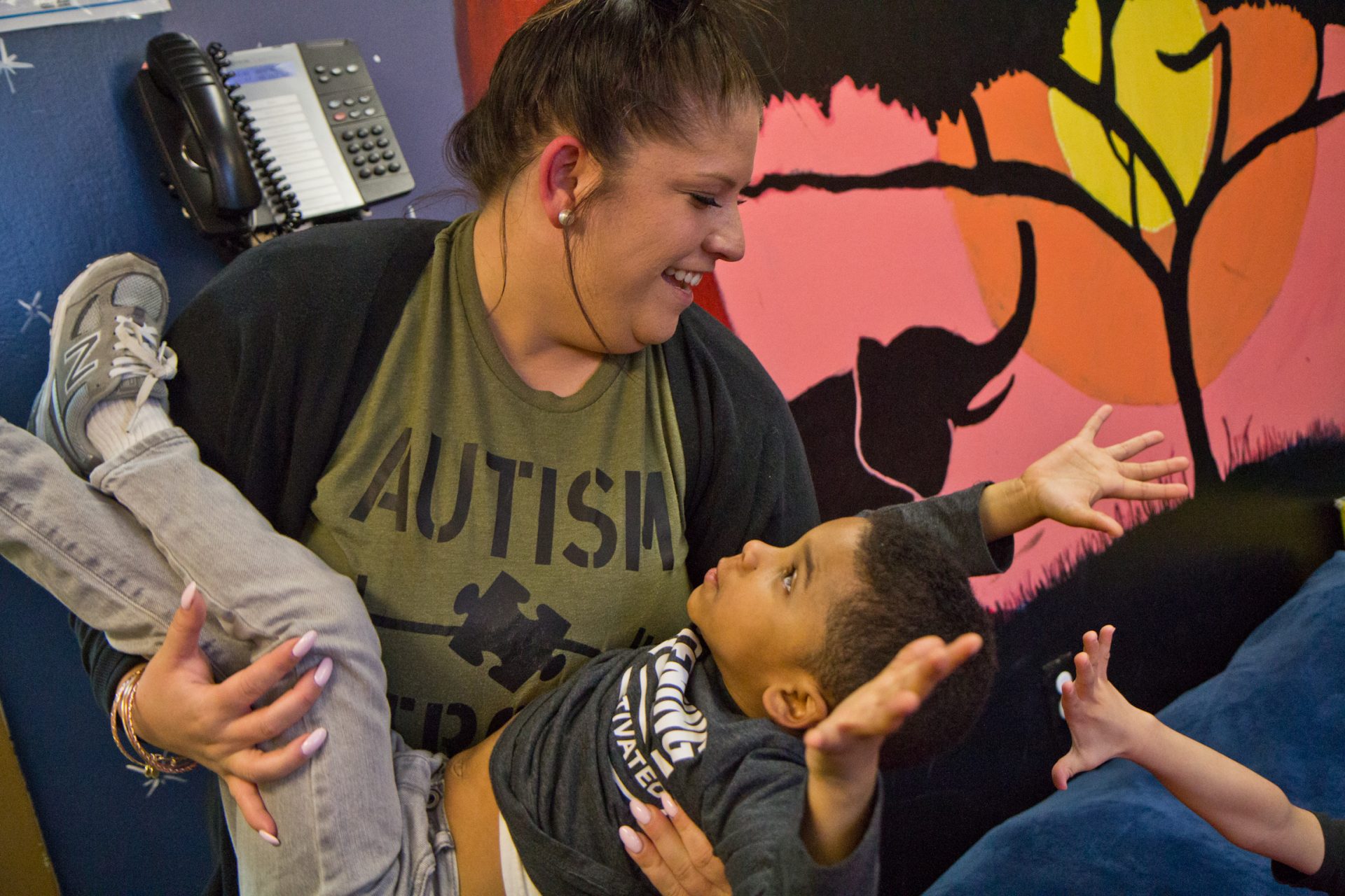 SPIN teacher Anne McCrane tosses a preschool student around during playtime.