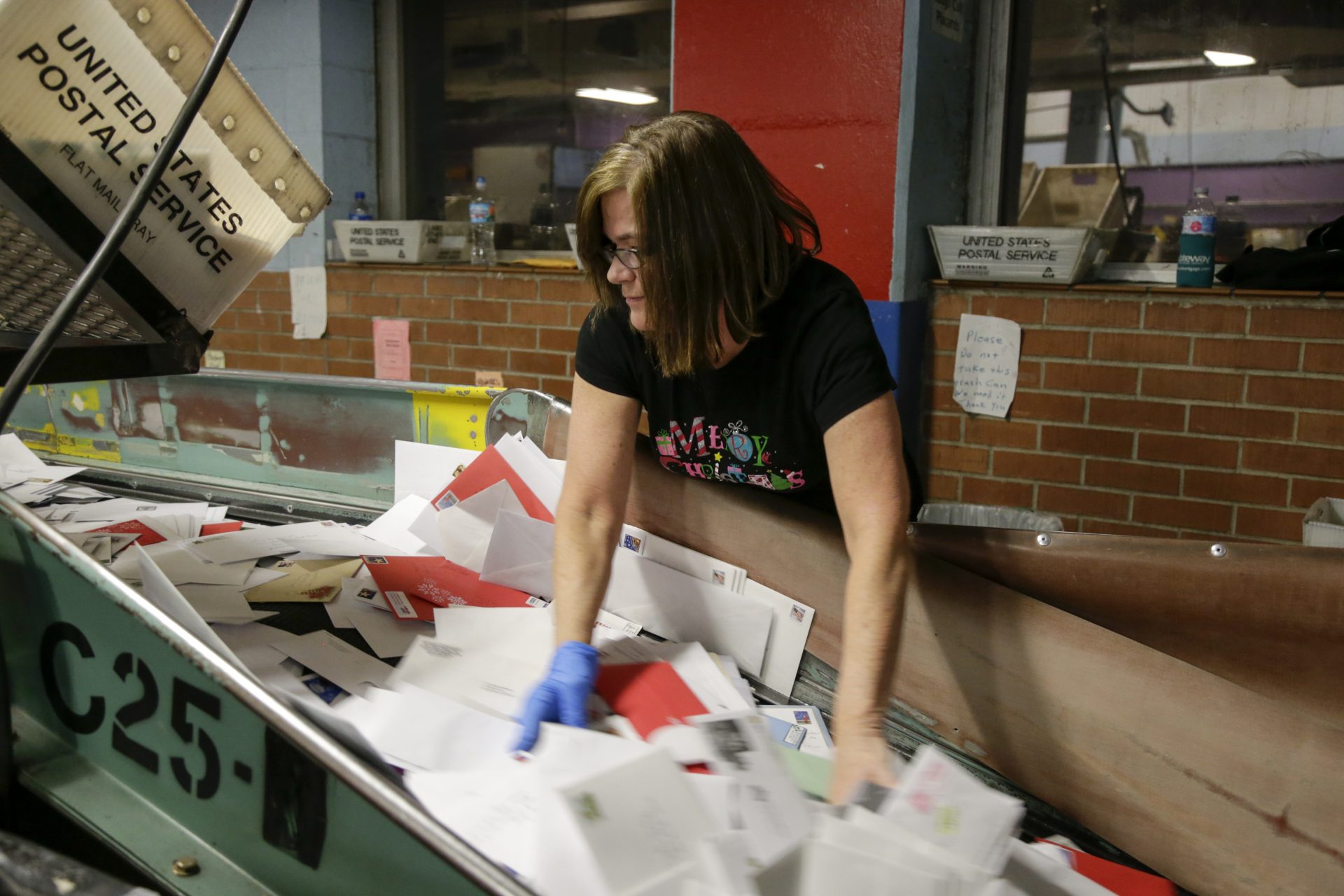 FILE PHOTO: Postal Service employee Mary Lichtenwalt sorts mail at a conveyor belt at the main post office in Omaha, Neb., Thursday, Dec. 14, 2017.