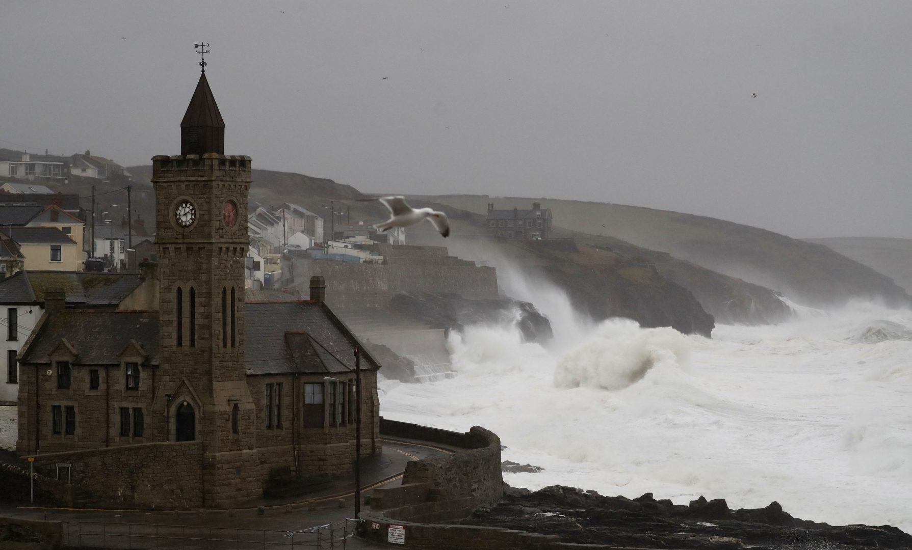 Powerful waves break on the shoreline around the small port of Porthleven, south west England, Sunday, Feb. 16, 2020. Storm Dennis roared across Britain on Sunday, lashing towns and cities with high winds and dumping so much rain that authorities urged residents to protect themselves from 